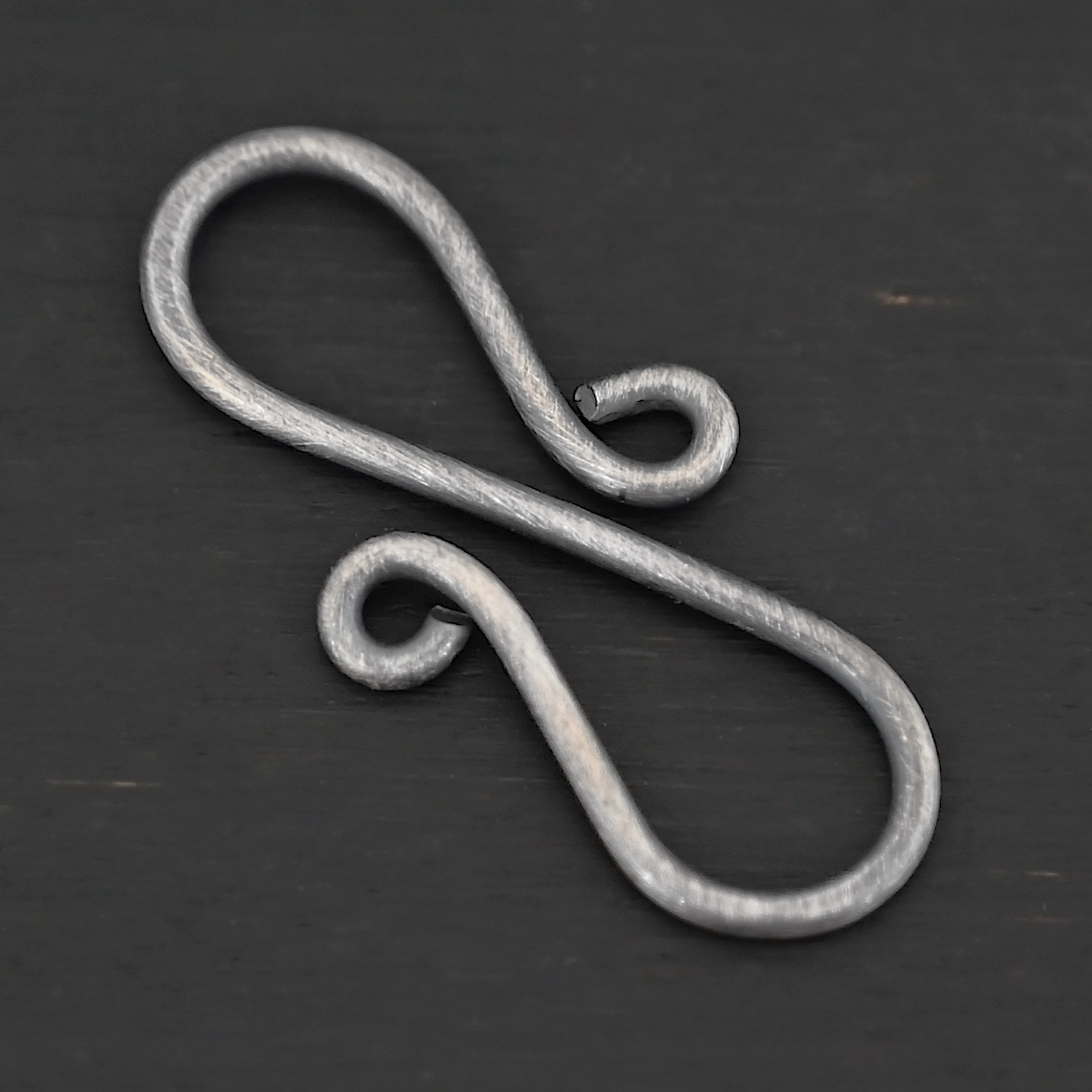 Summer S Clasp - oxidized smooth shown on dark background