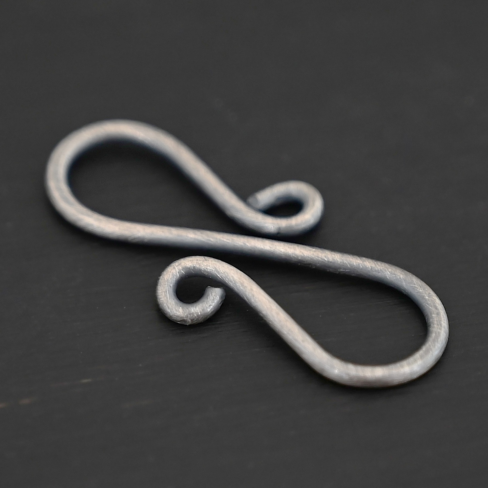 Summer S Clasp - oxidized smooth shown on dark background