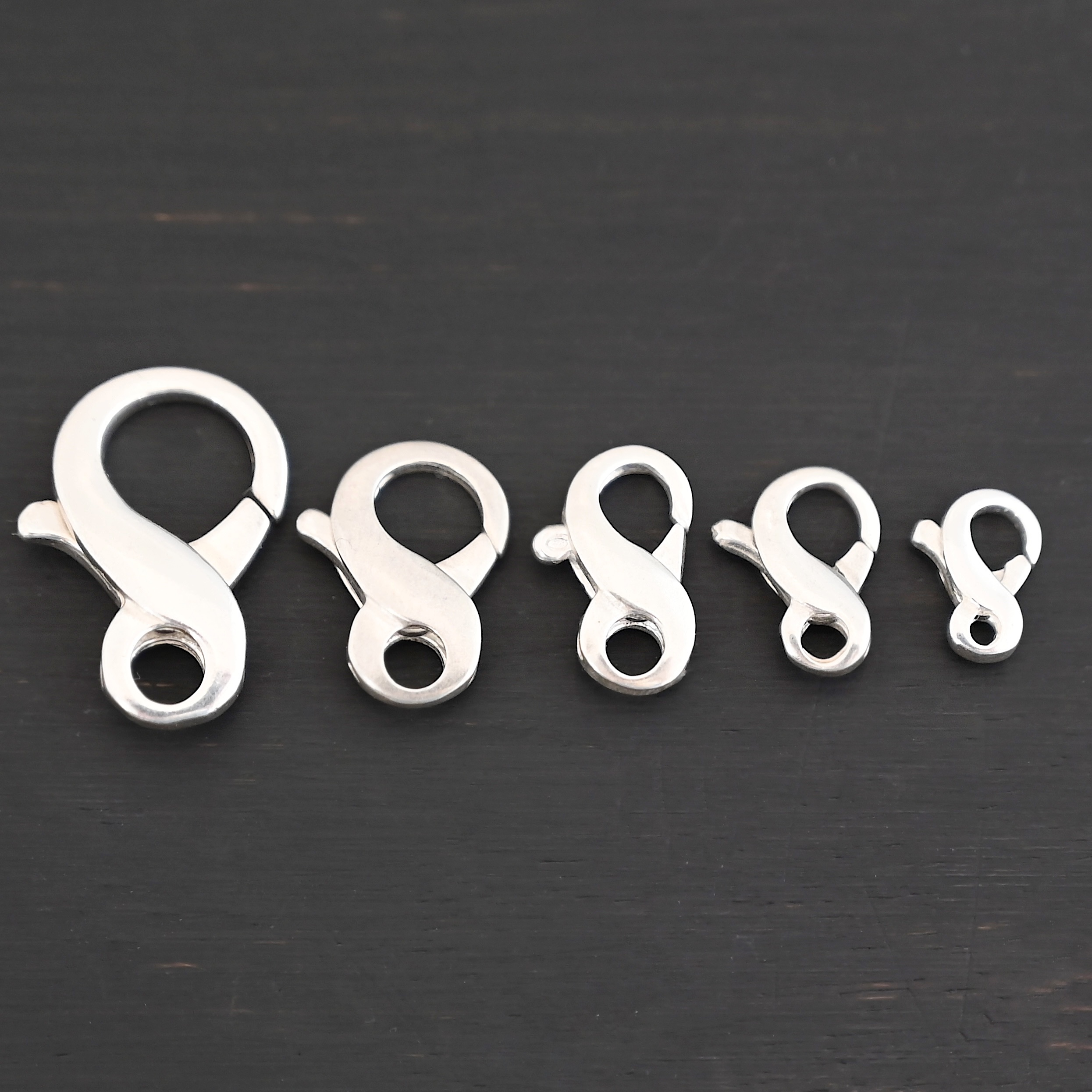 Faith Figure Eight Clasp - shiny Faith Figure Eight Clasp - shiny shown on dark background