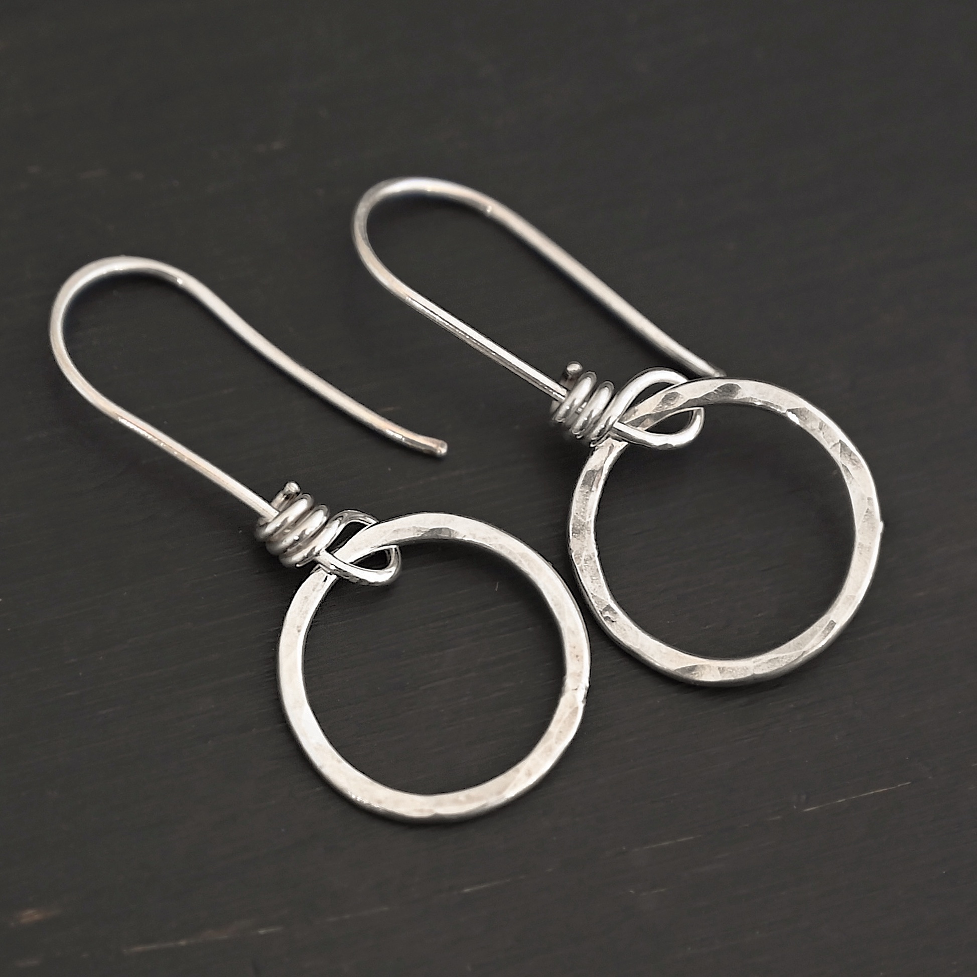 Sterling Silver Flora Hammered Circle Earrings shiny shown on dark background