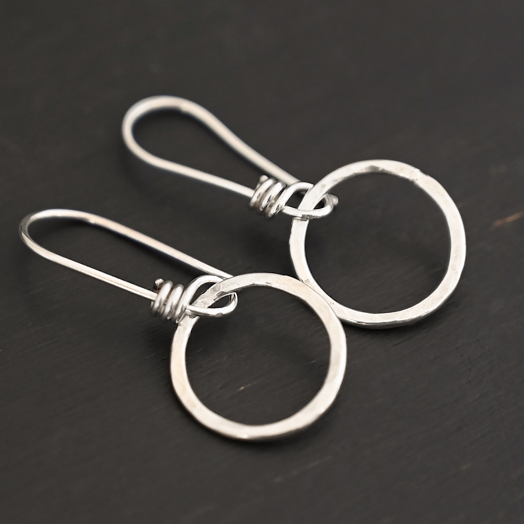 Sterling Silver Flora Hammered Circle Earrings shiny shown on dark background