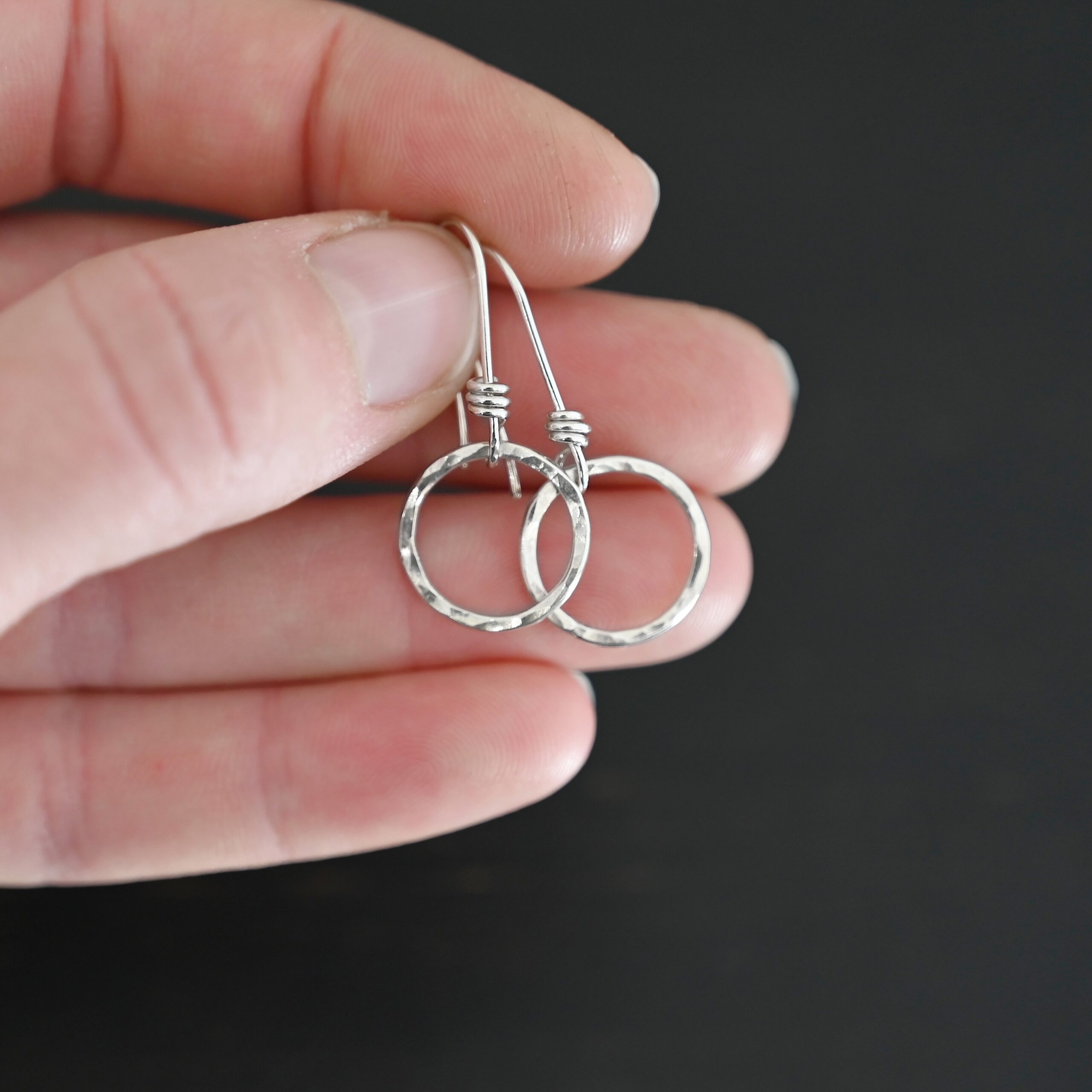 Sterling Silver Flora Hammered Circle Earrings shiny shown in hand