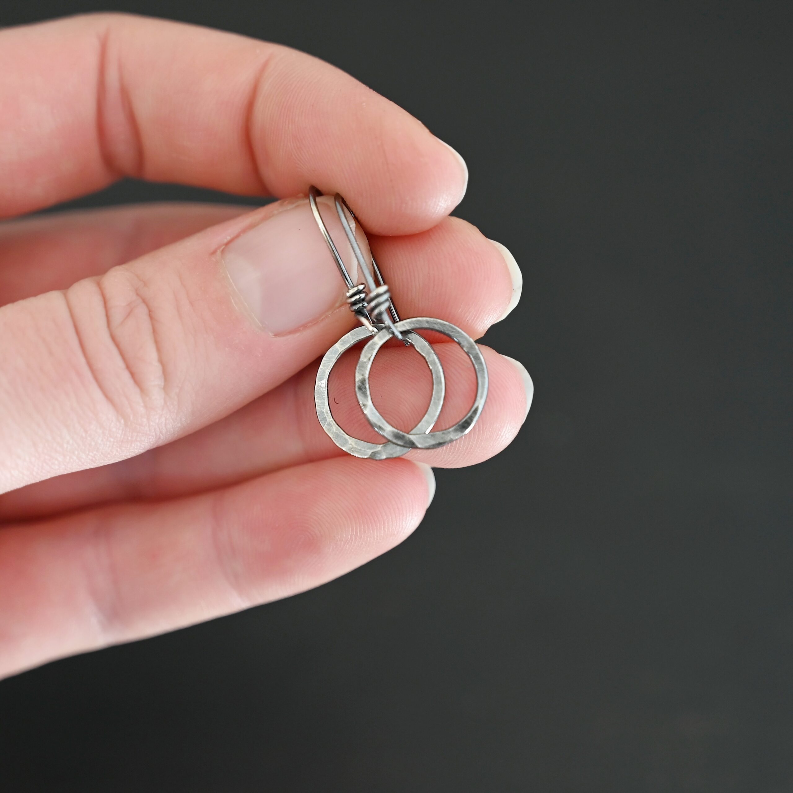 Sterling Silver Flora Hammered Circle Earrings oxidized shown in hand