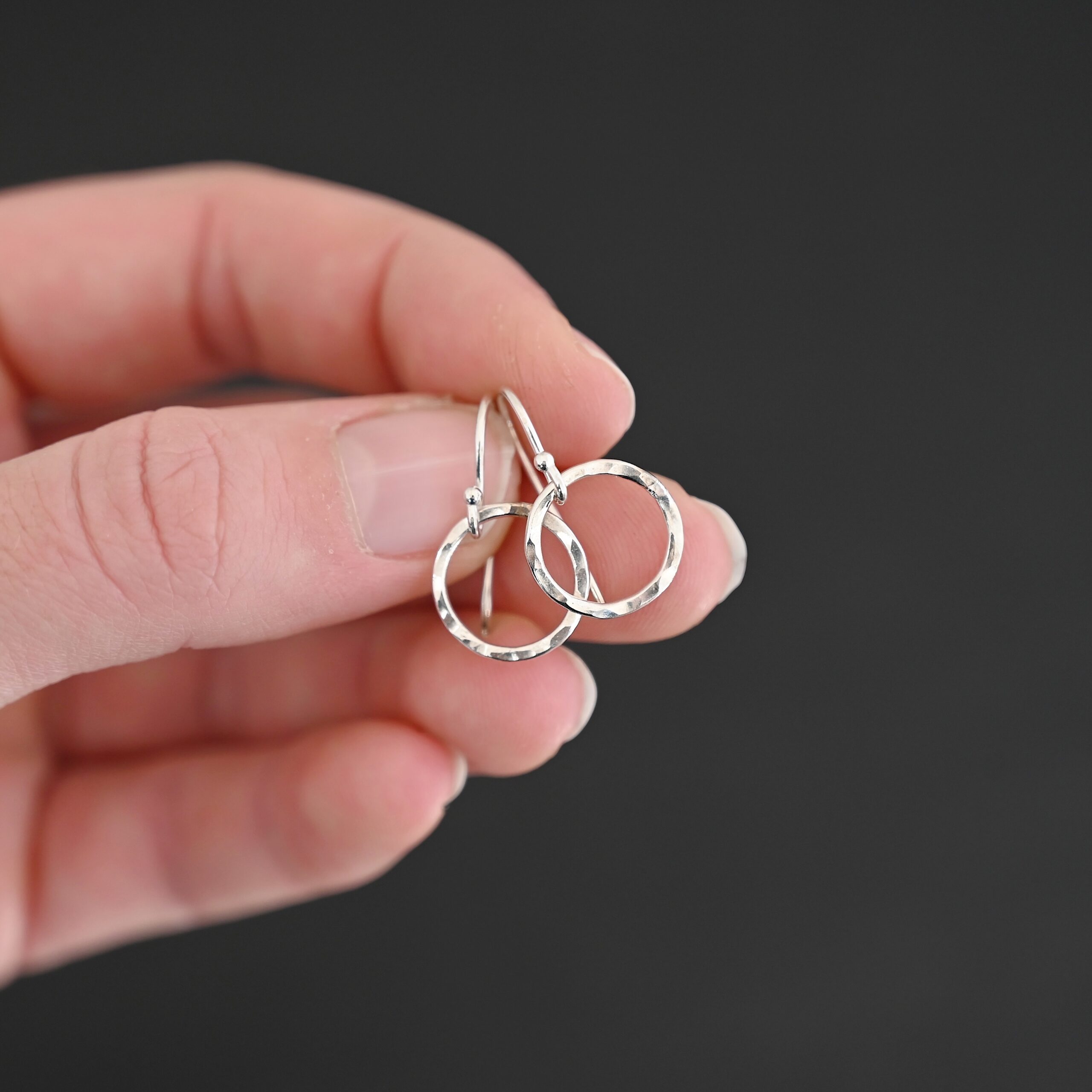 Sterling Silver Fawna Hammered Circle Earrings shiny shown in hand