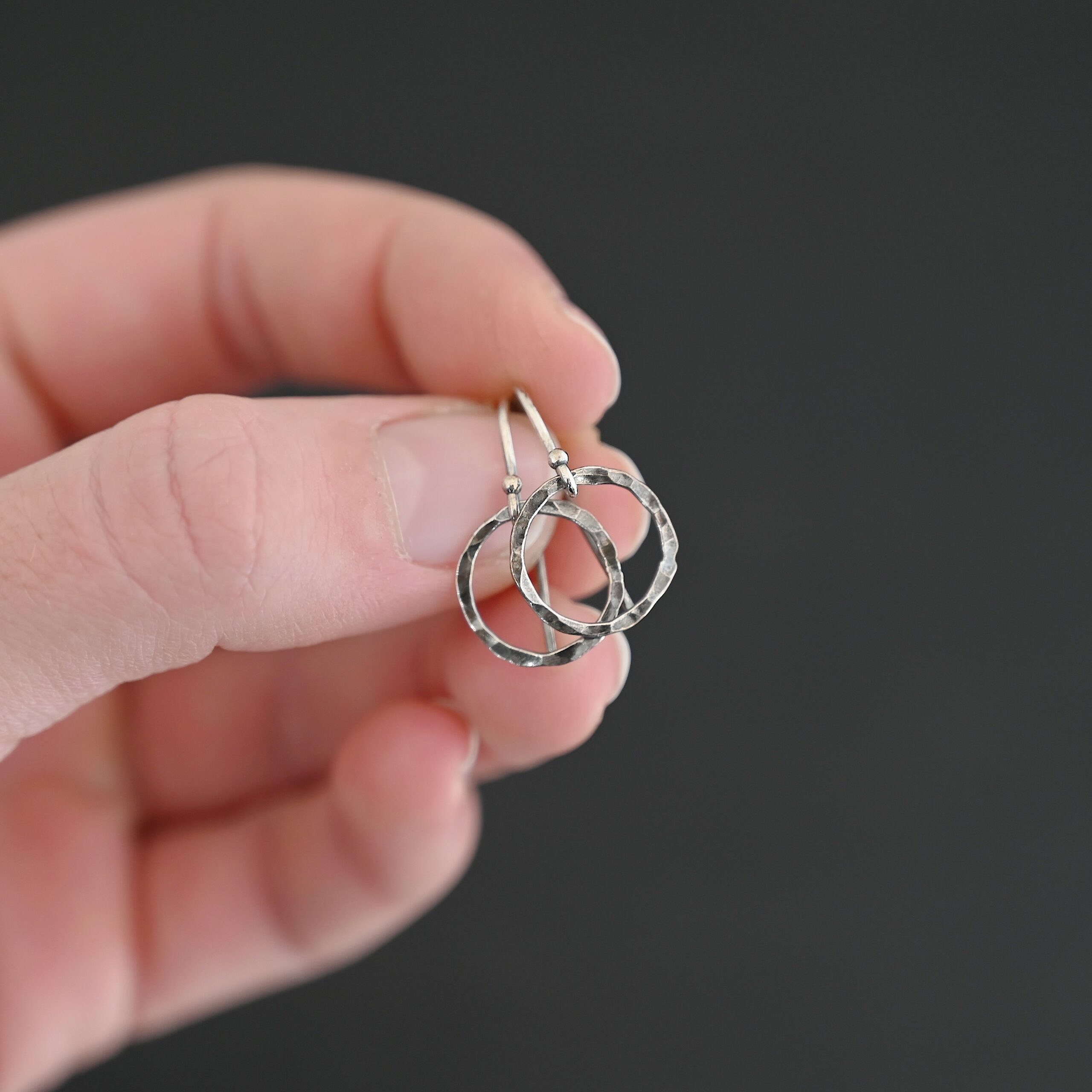 Sterling Silver Fawna Hammered Circle Earrings oxidized shown in hand