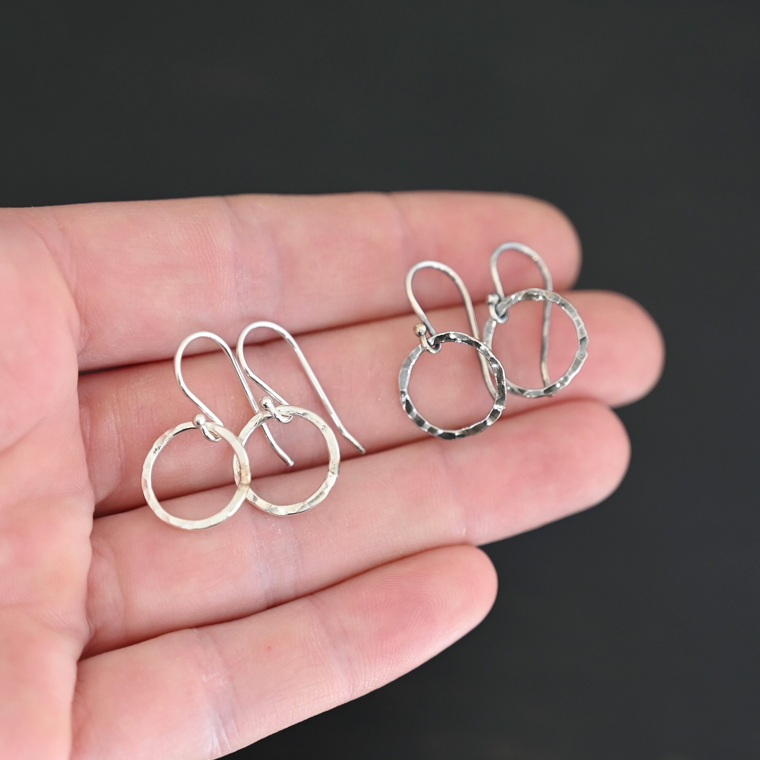 Sterling Silver Fawna Hammered Circle Earrings oxidized and shiny shown in hand