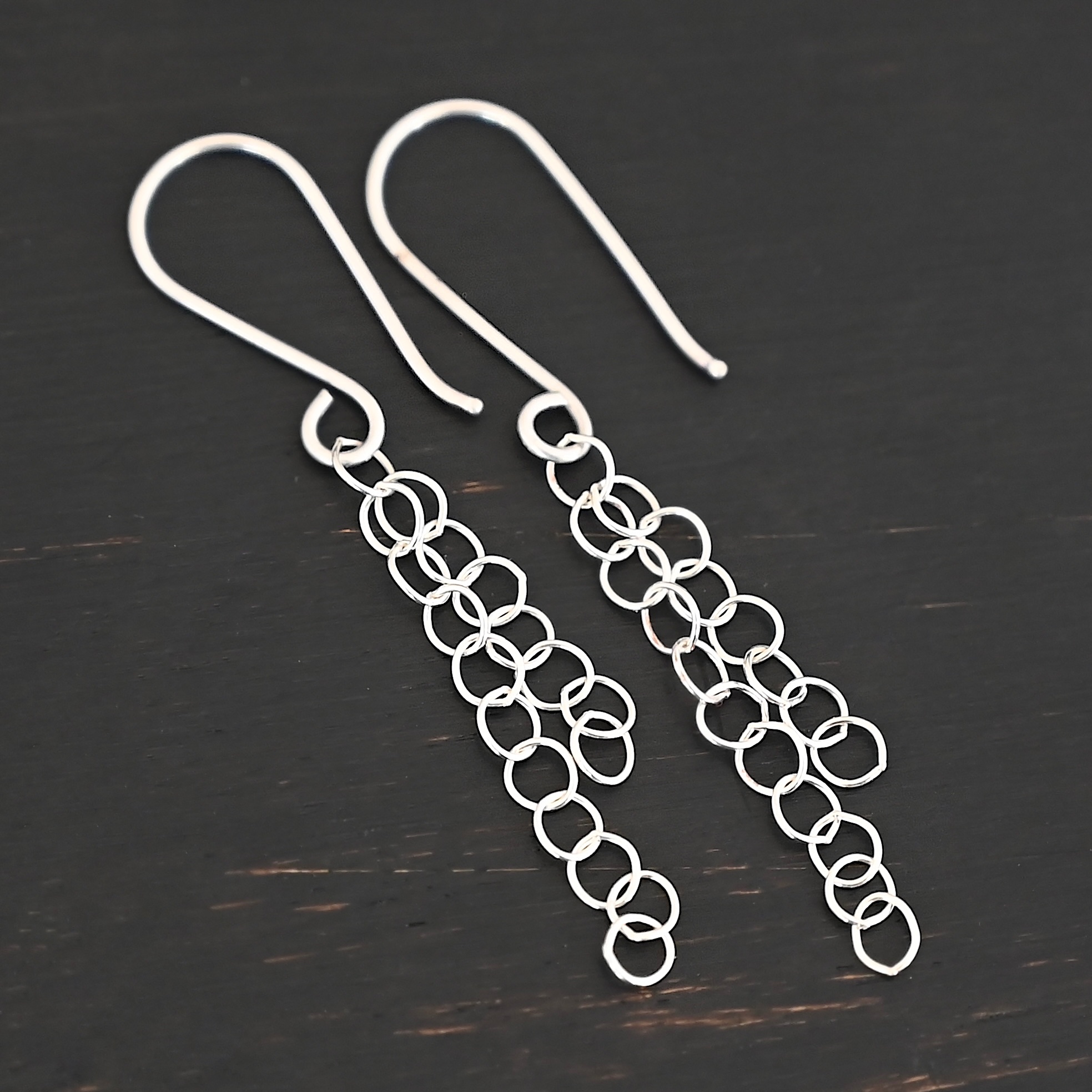 Sterling Silver Florella Dangle Earrings shiny shown on dark background