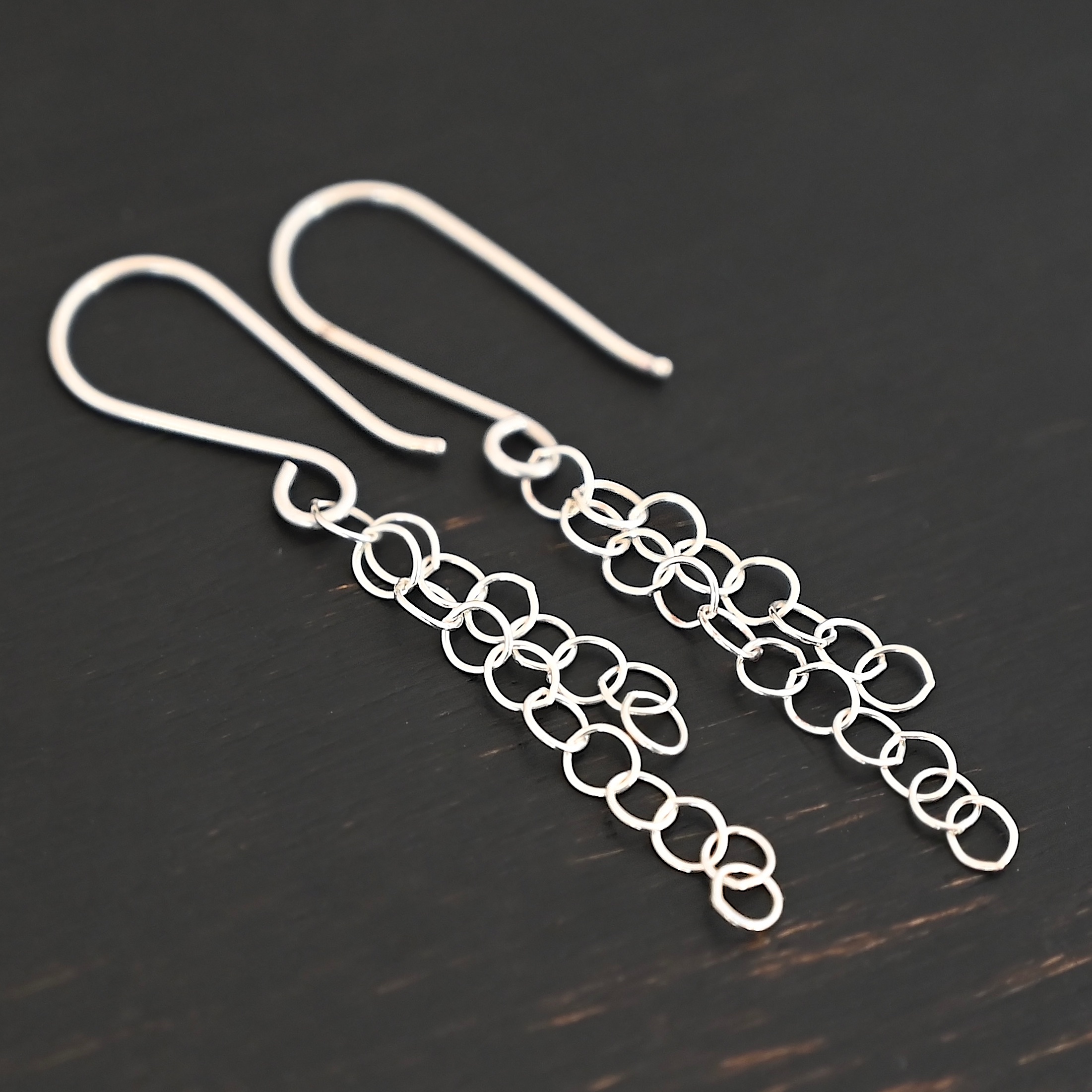 Sterling Silver Florella Dangle Earrings shiny shown on dark background