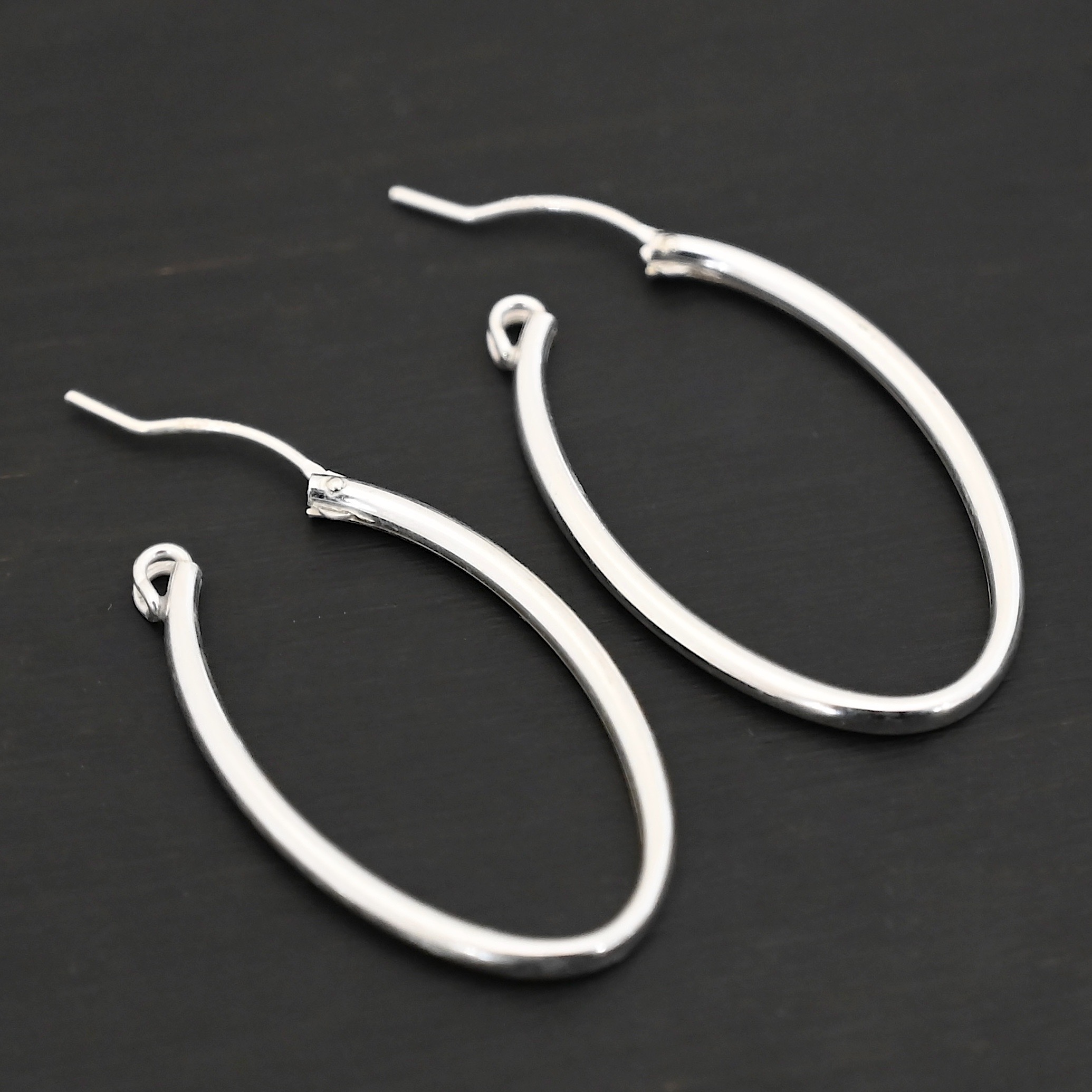 Sterling Silver Frances Oval Hoop Earring 34mm shown on dark background