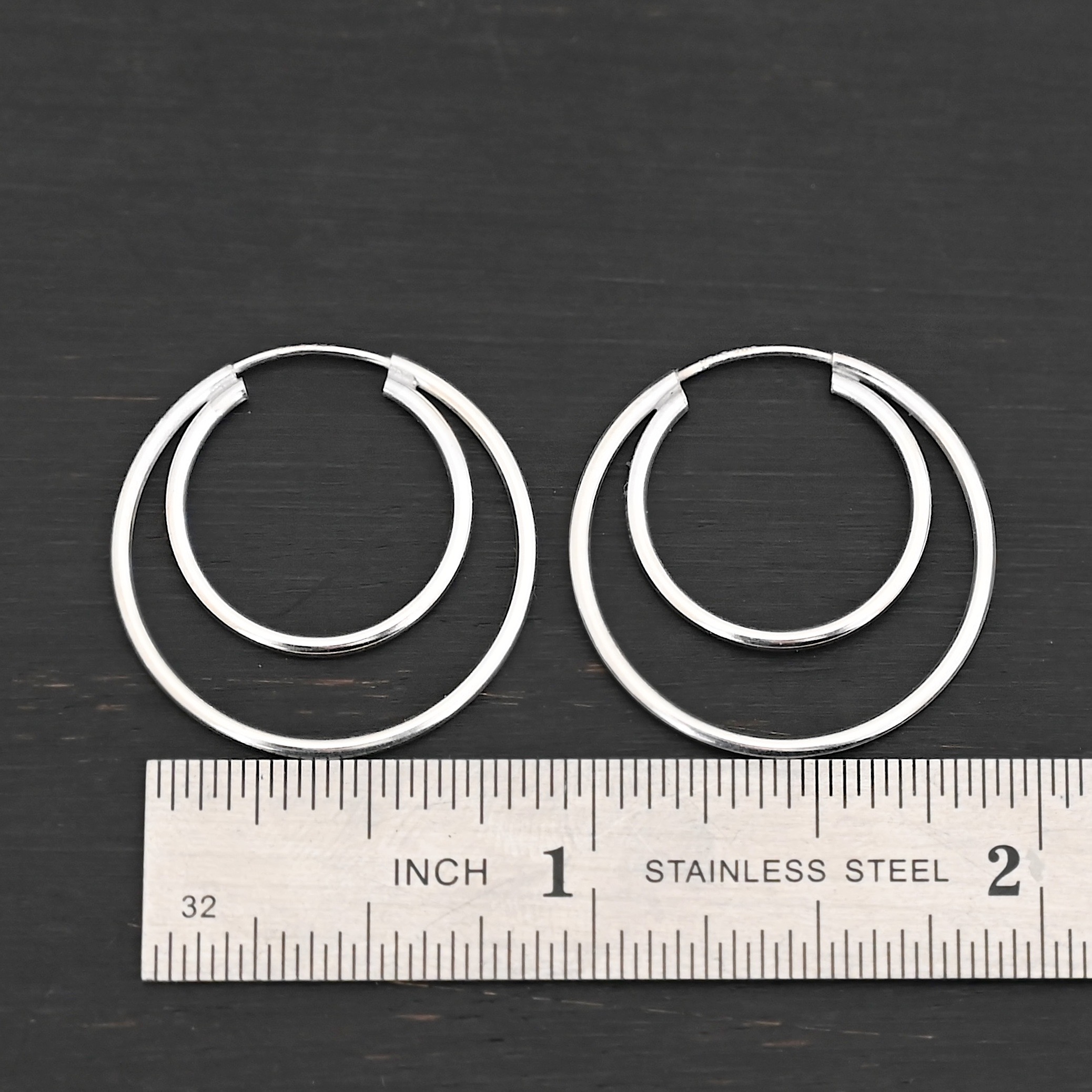 Sterling Silver Fern Double Hoop Earrings 25mm shiny shown by ruler