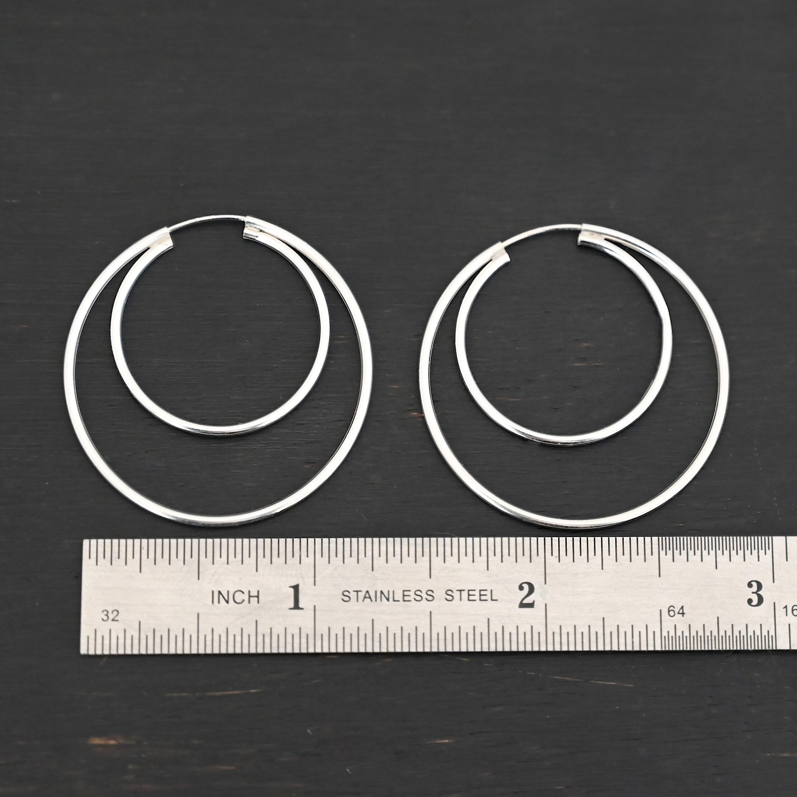 Sterling Silver Fern Double Hoop Earrings 35mm shiny shown by ruler