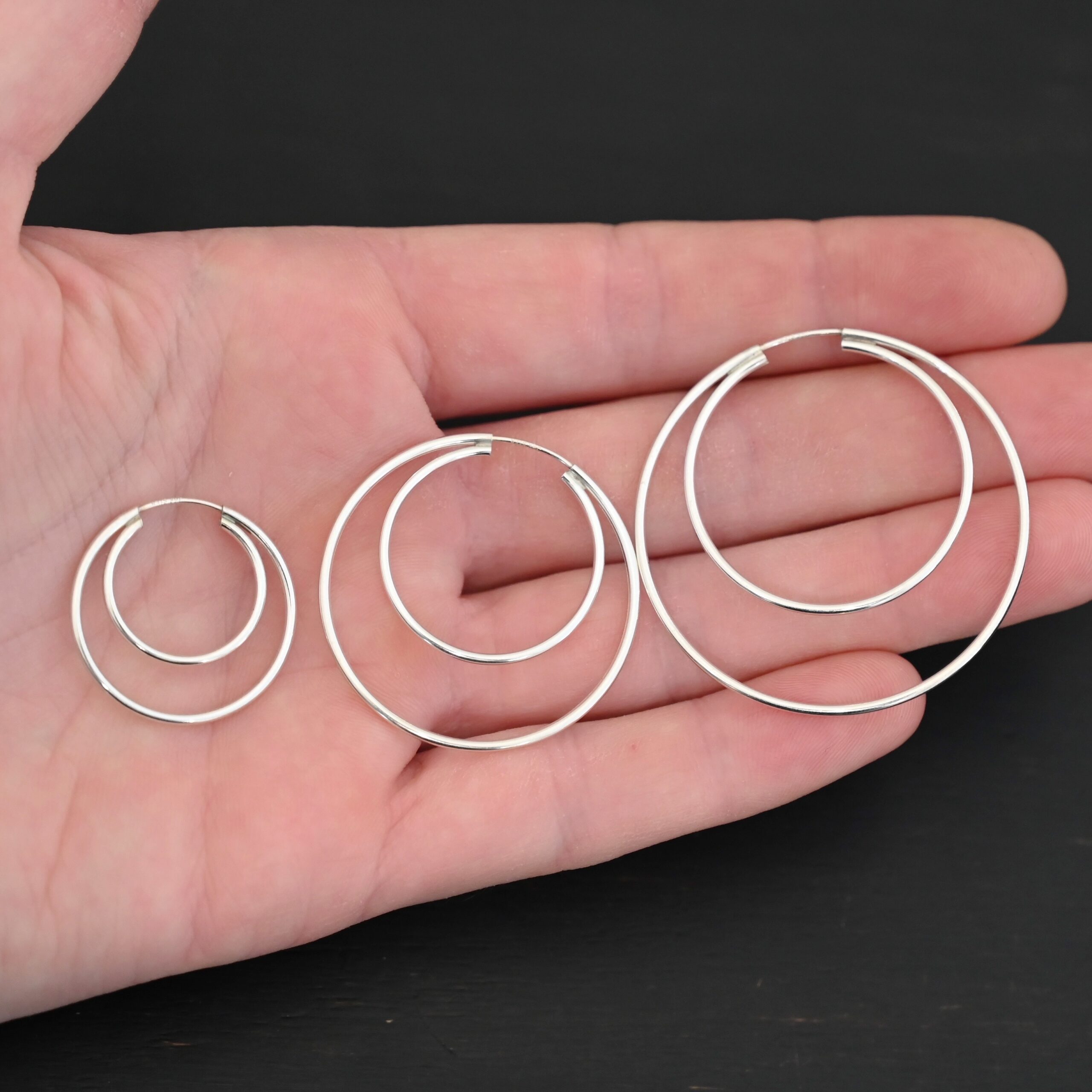 Sterling Silver Fern Double Hoop Earrings all sizes shiny shown in hand