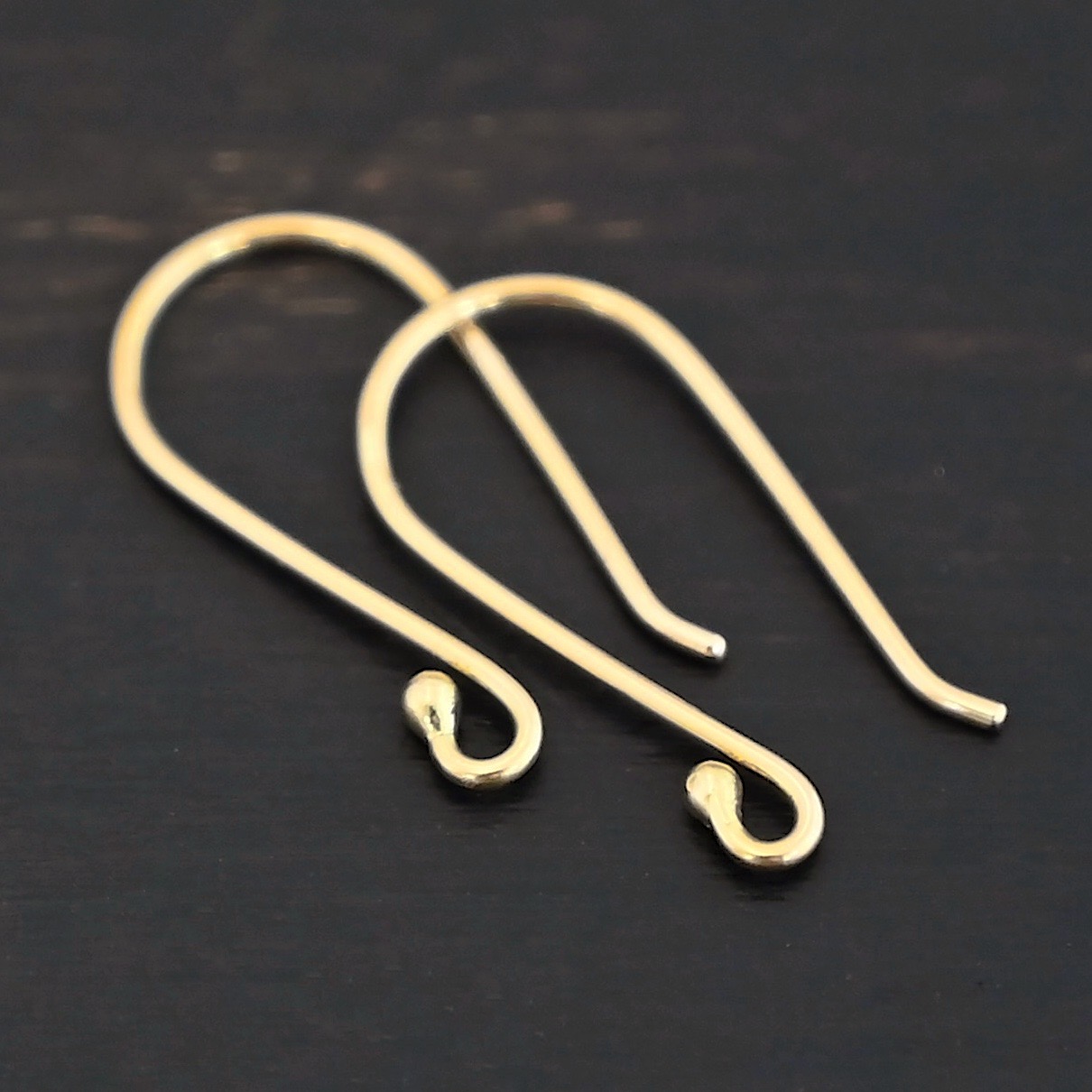 18k gold Whitney Ear Wire shown on dark background
