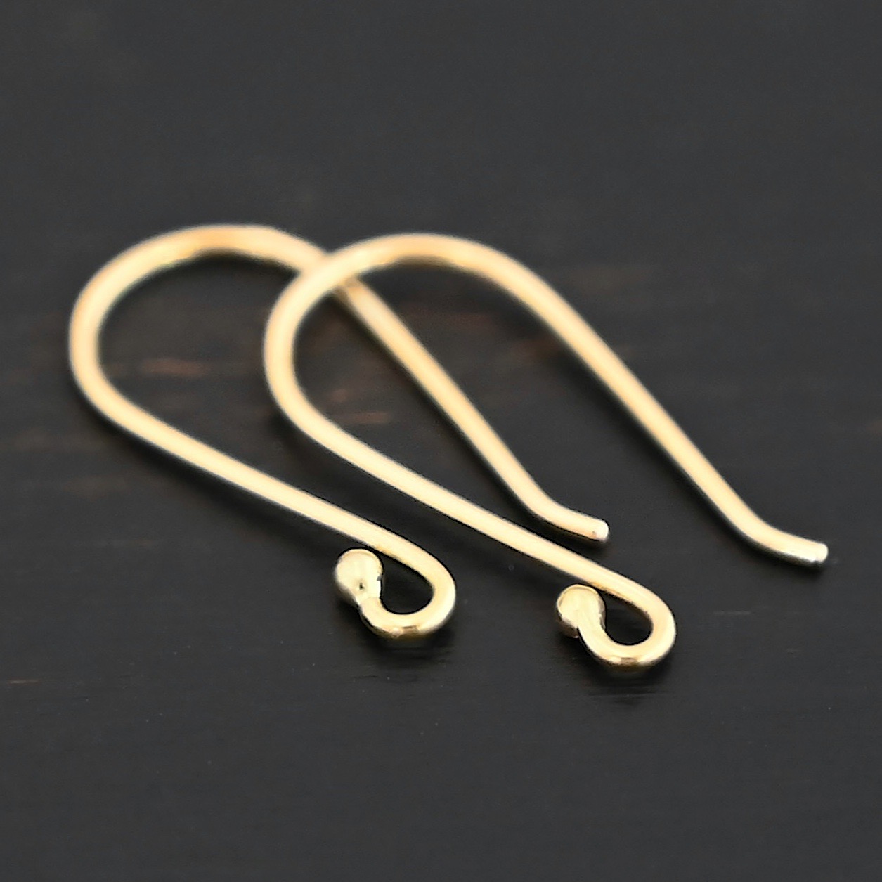 18k gold Whitney Ear Wire shown on dark background