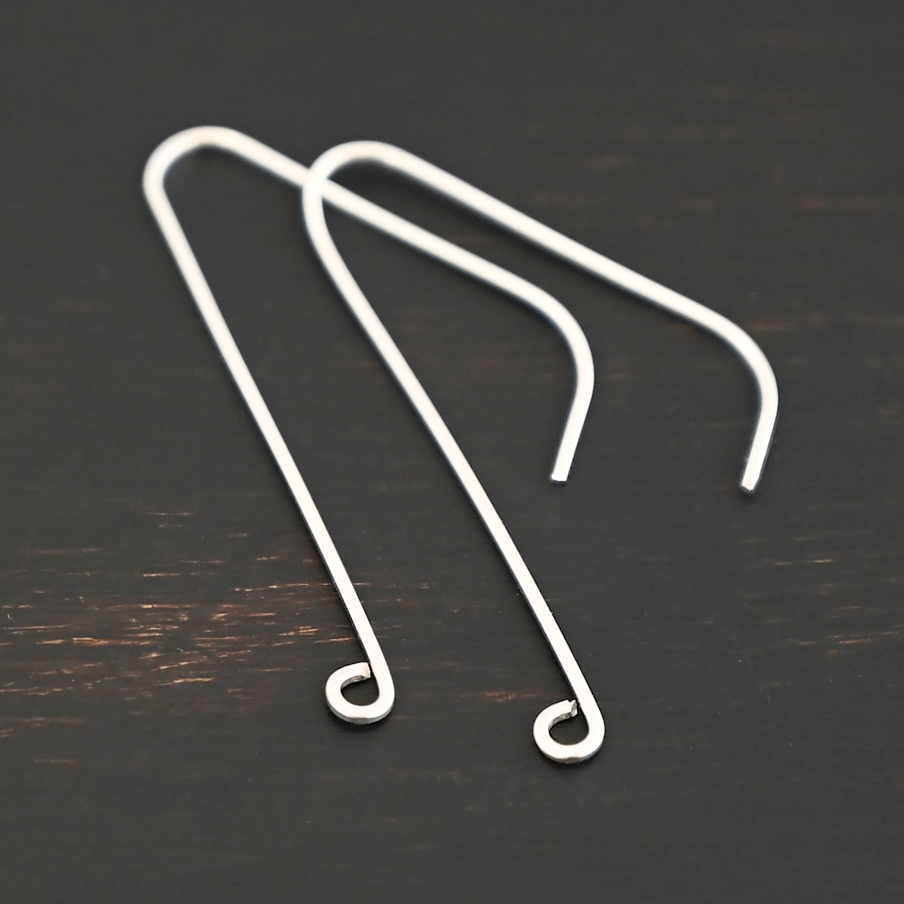 sterling silver Whimsical Ear Wire - shiny 1.5" shown on dark background