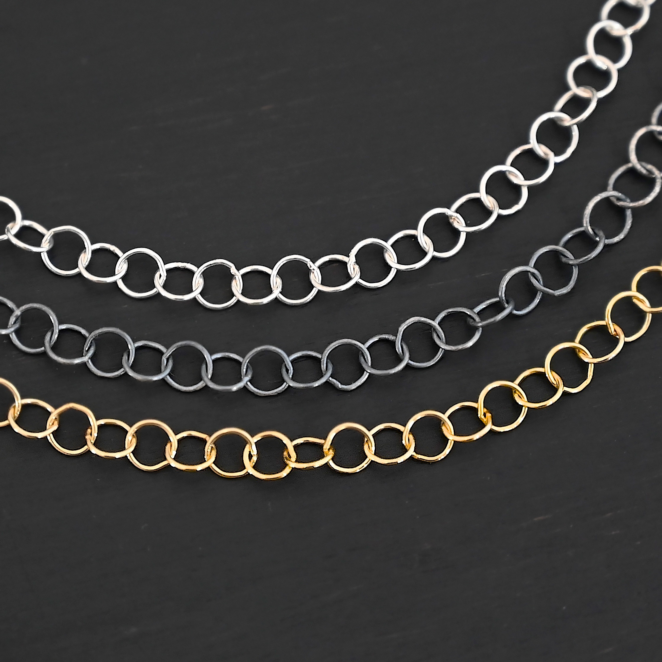 Round Extension oxidized sterling silver, shiny sterling silver, and 14k gold filled shown on dark background