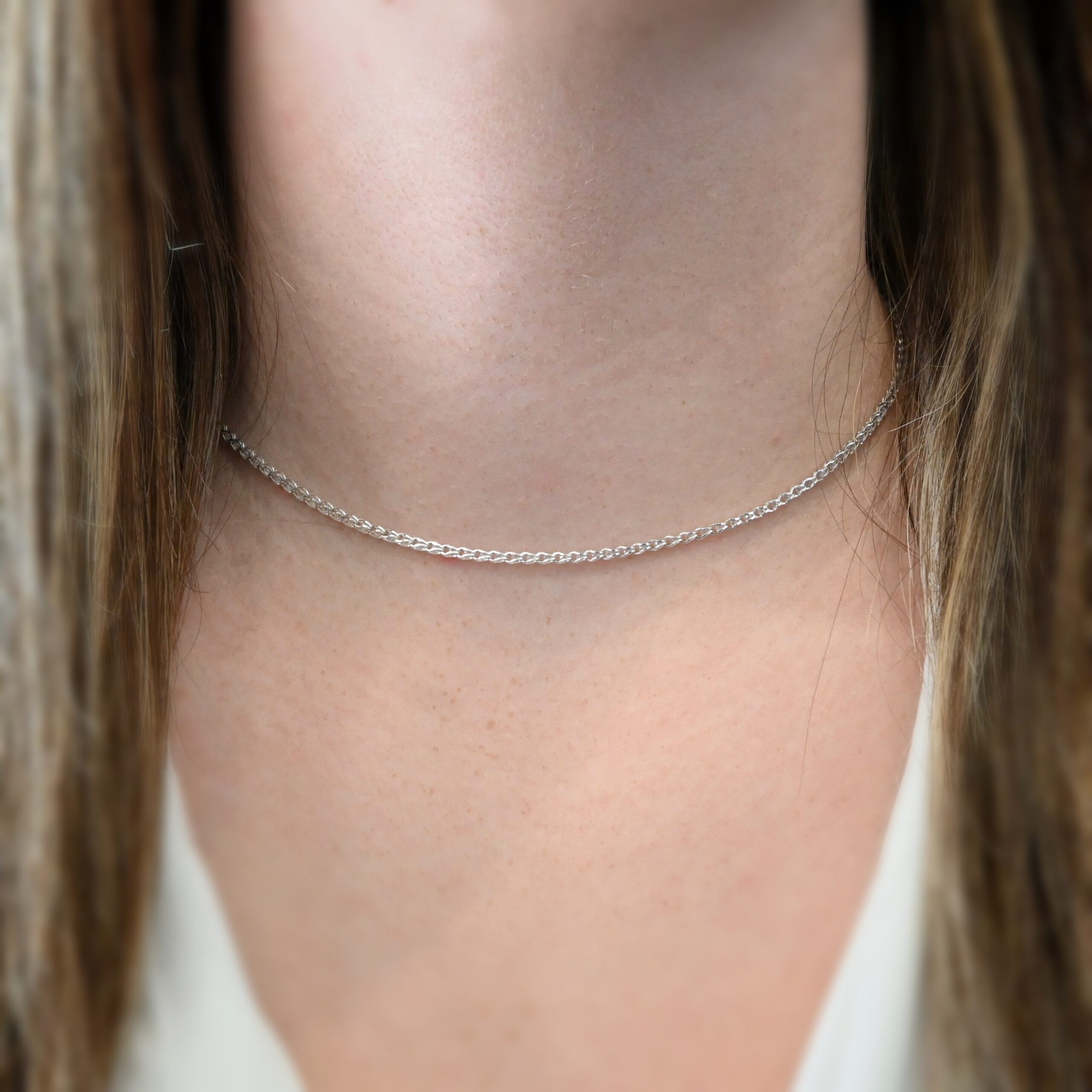 Scarlett Chain Shiny 15-17" shown on model with white shirt and brown hair