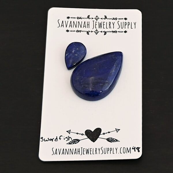 Swordfish Lapis cabochon parcel shown on business card