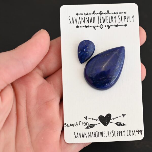 Swordfish Lapis cabochon parcel shown in hand
