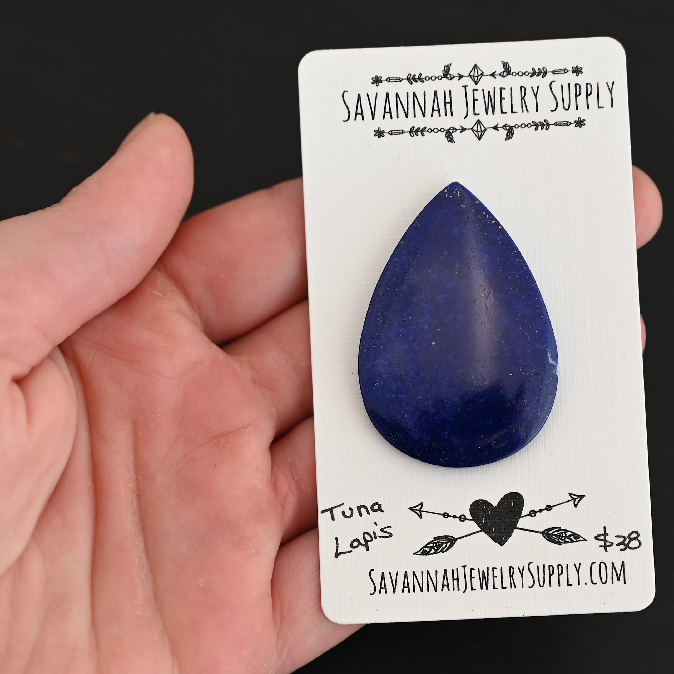 Tuna Lapis cabochon parcel shown in hand