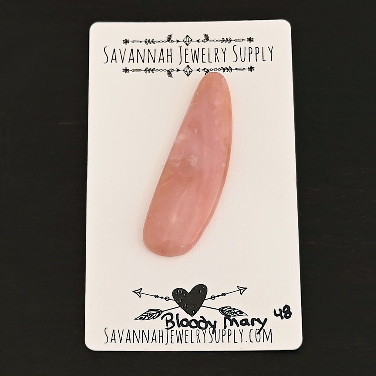 Bloody Mary Pink Opal cabochon shown on business card