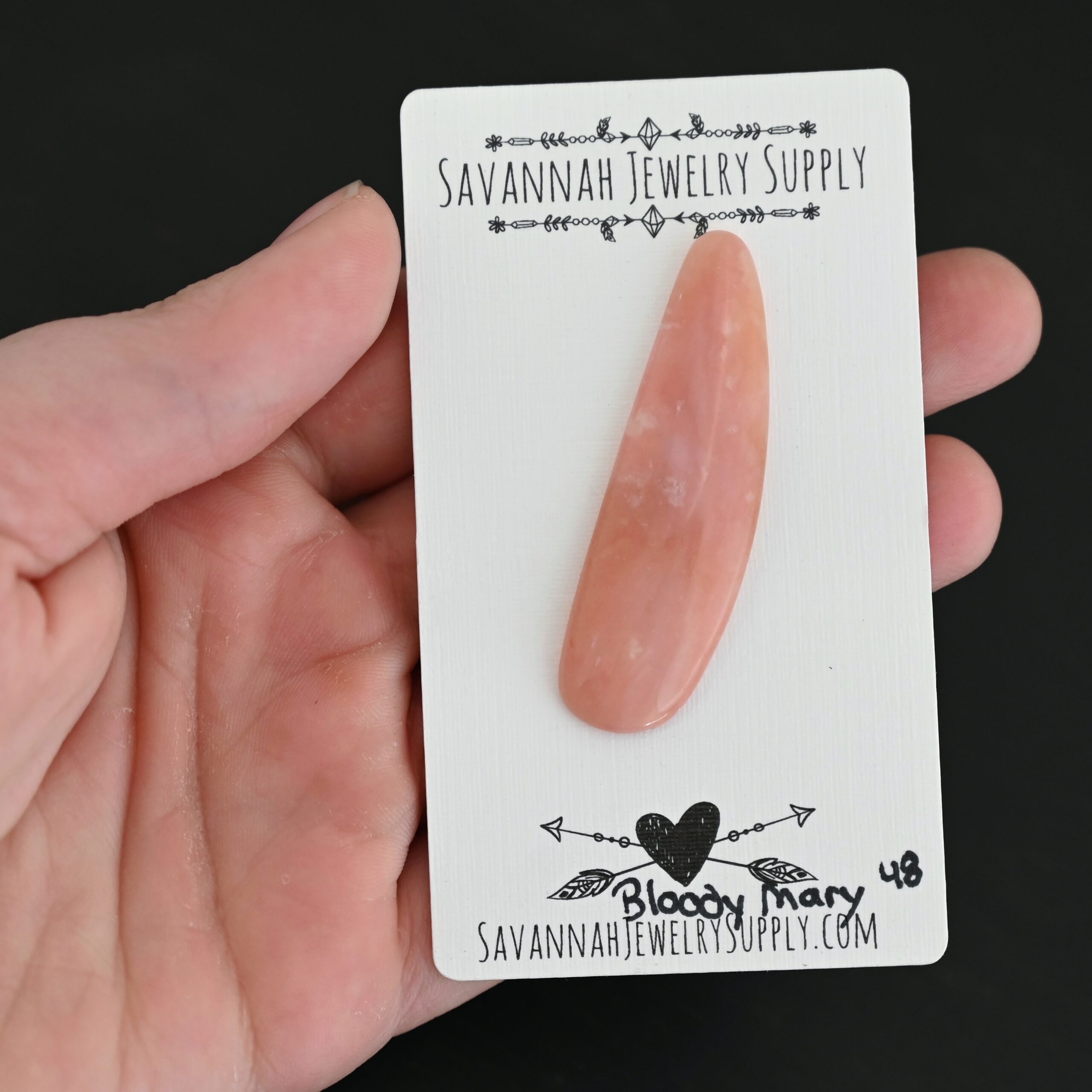 Bloody Mary Pink Opal cabochon shown in hand