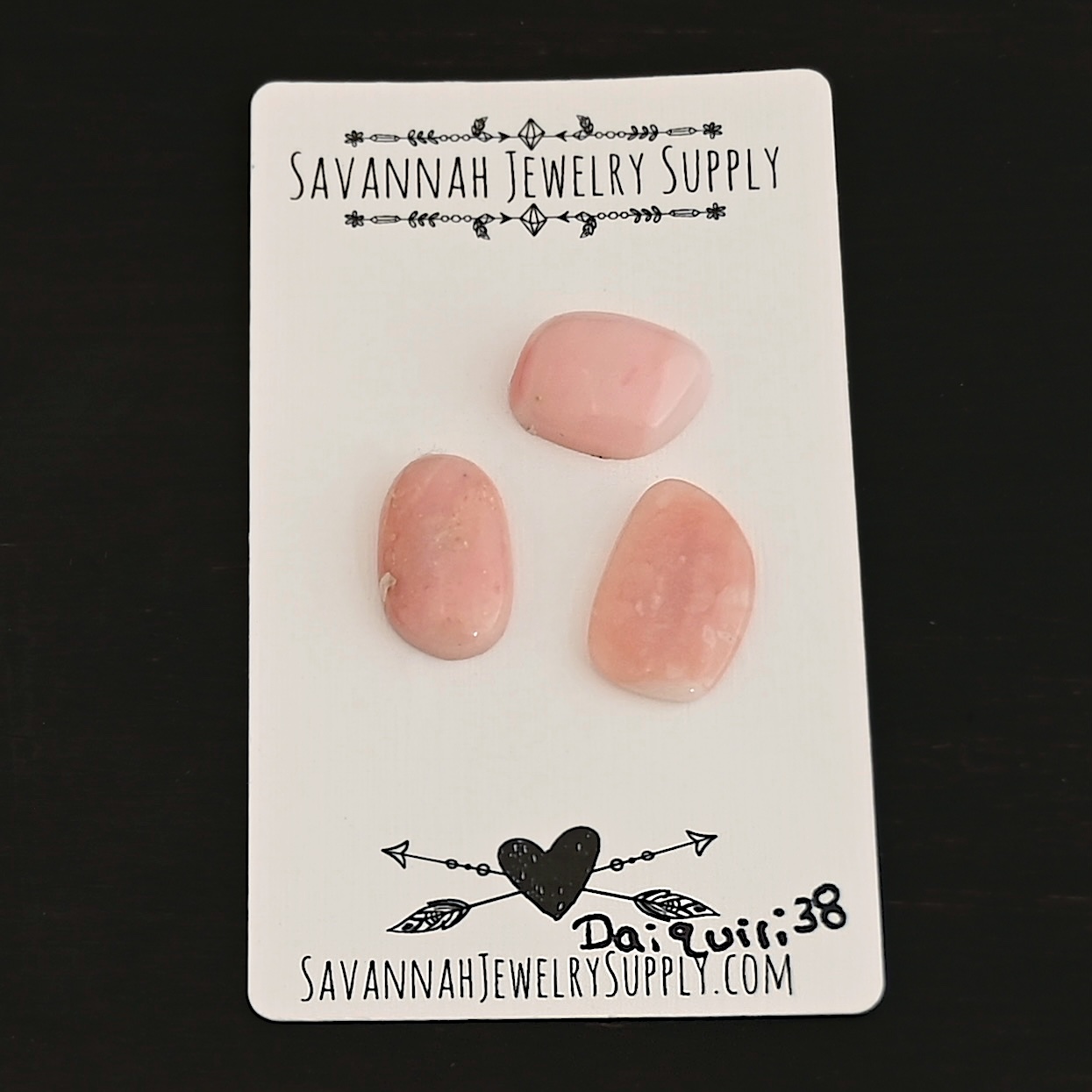 Daiquiri Pink Opal cabochon parcel shown on business card