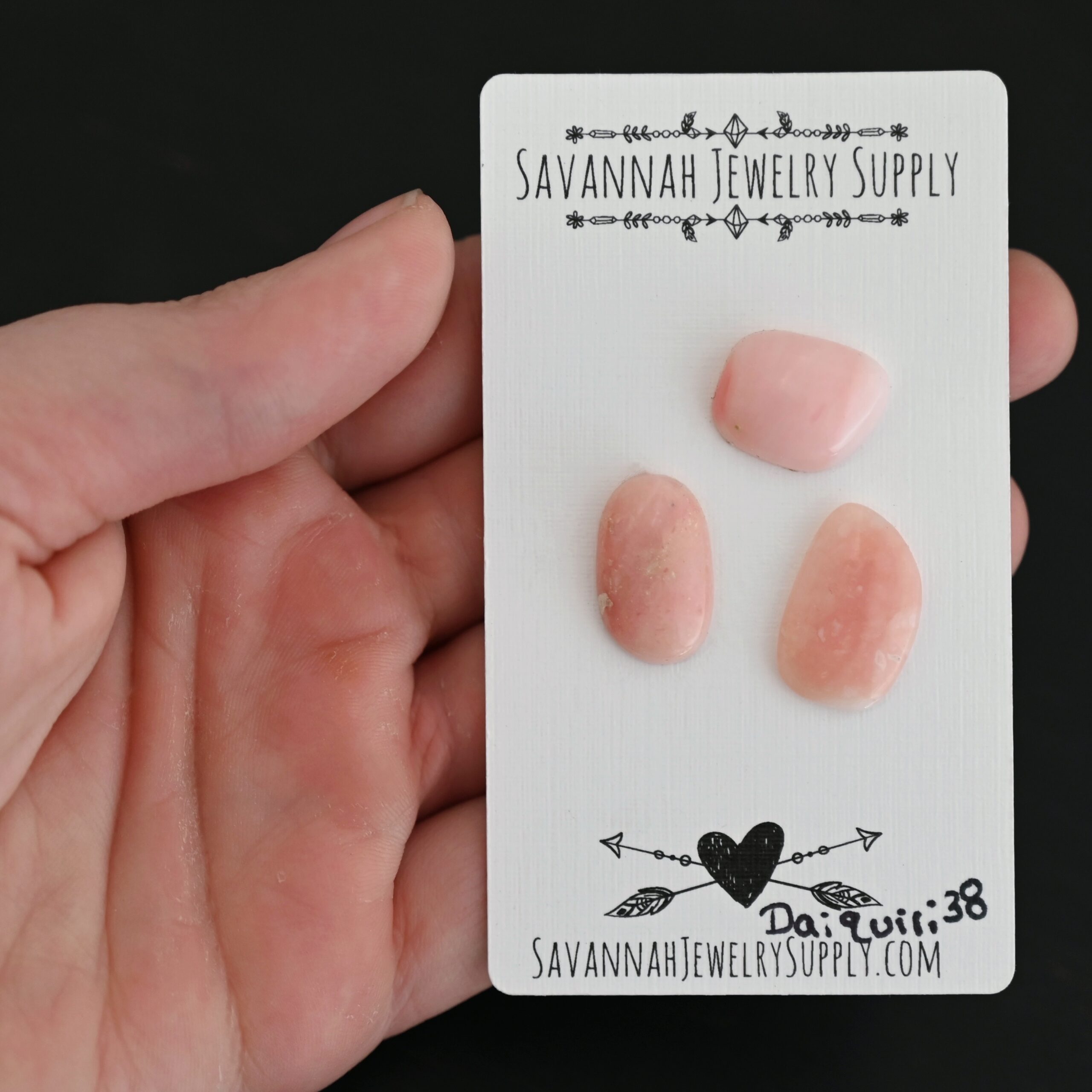 Daiquiri Pink Opal cabochon parcel shown in hand