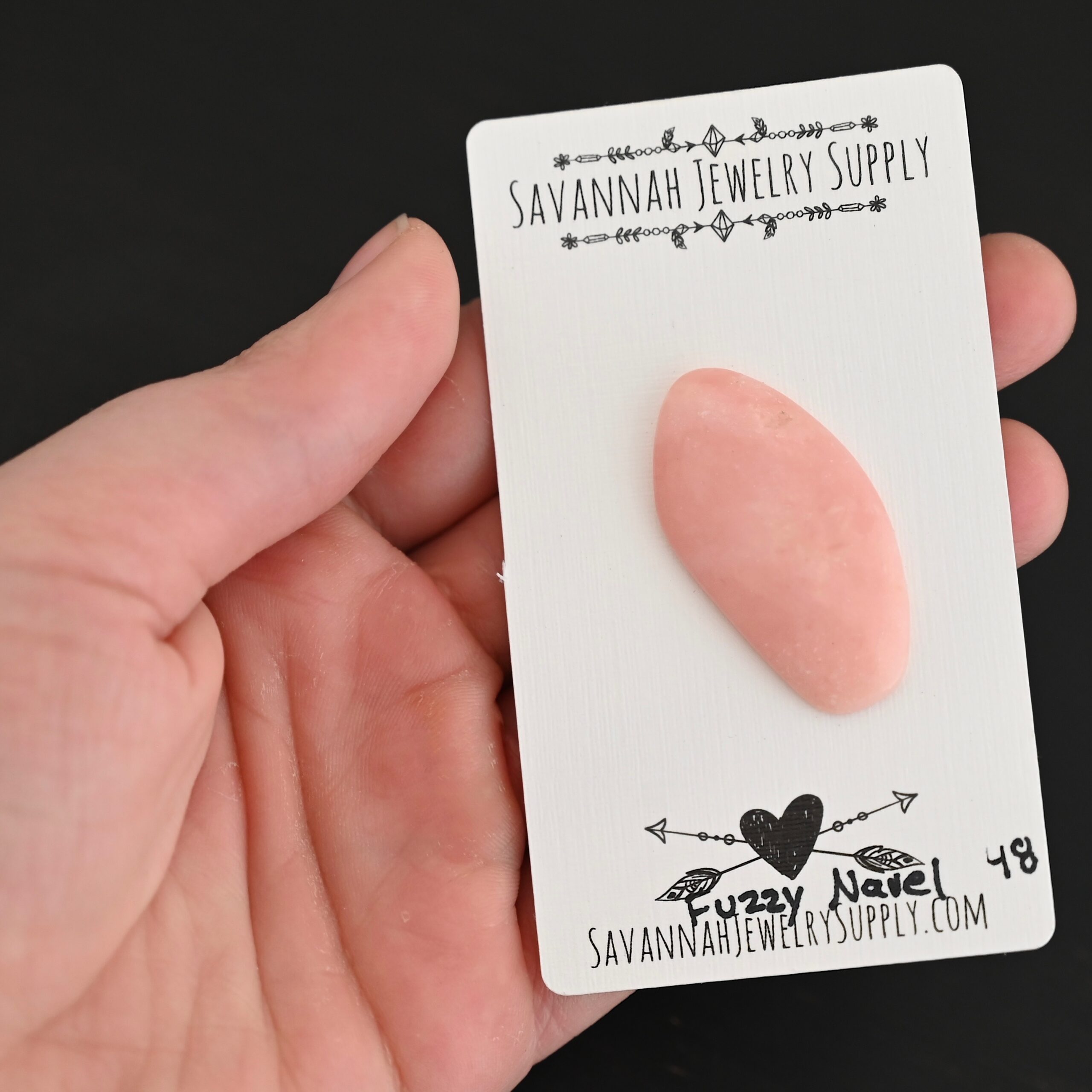 Fuzzy Navel Pink Opal cabochon parcel shown in hand