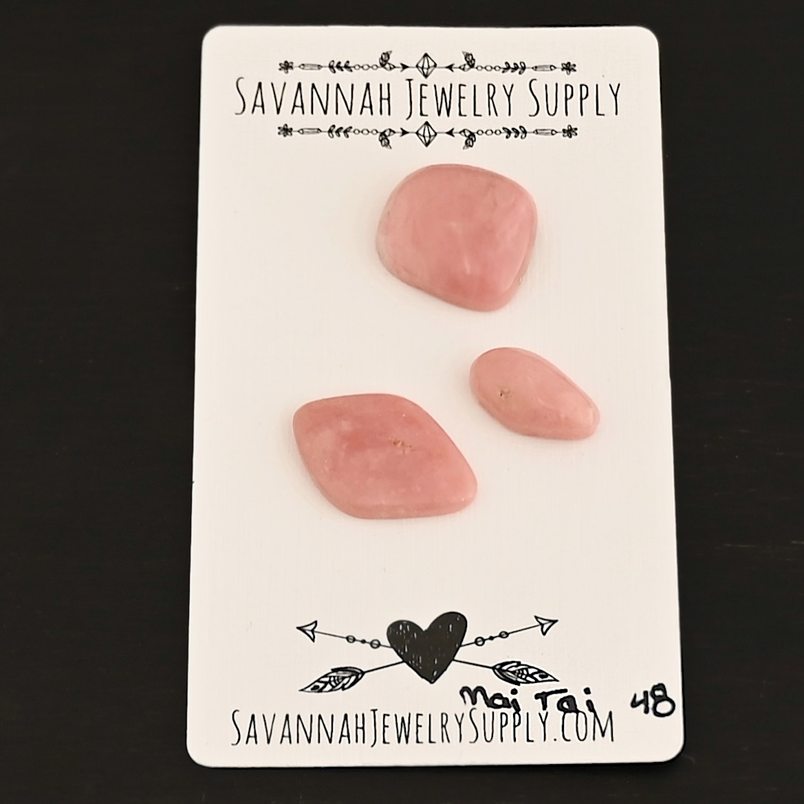 Mai Tai Pink Opal cabochon parcel shown on business card