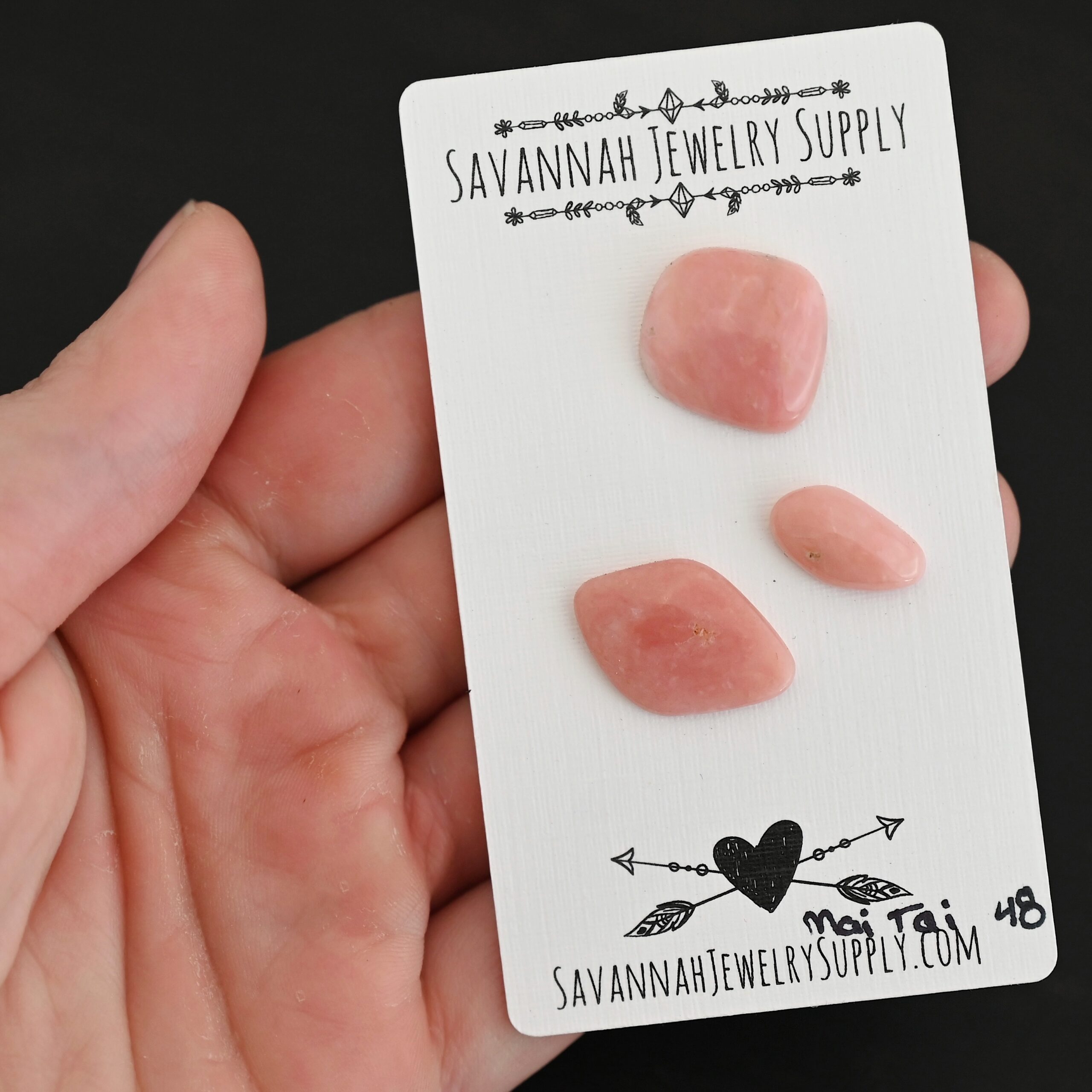 Mai Tai Pink Opal cabochon parcel shown in hand