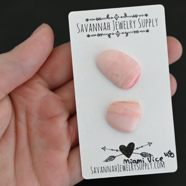 Miami Vice Pink Opal cabochon parcel shown in hand