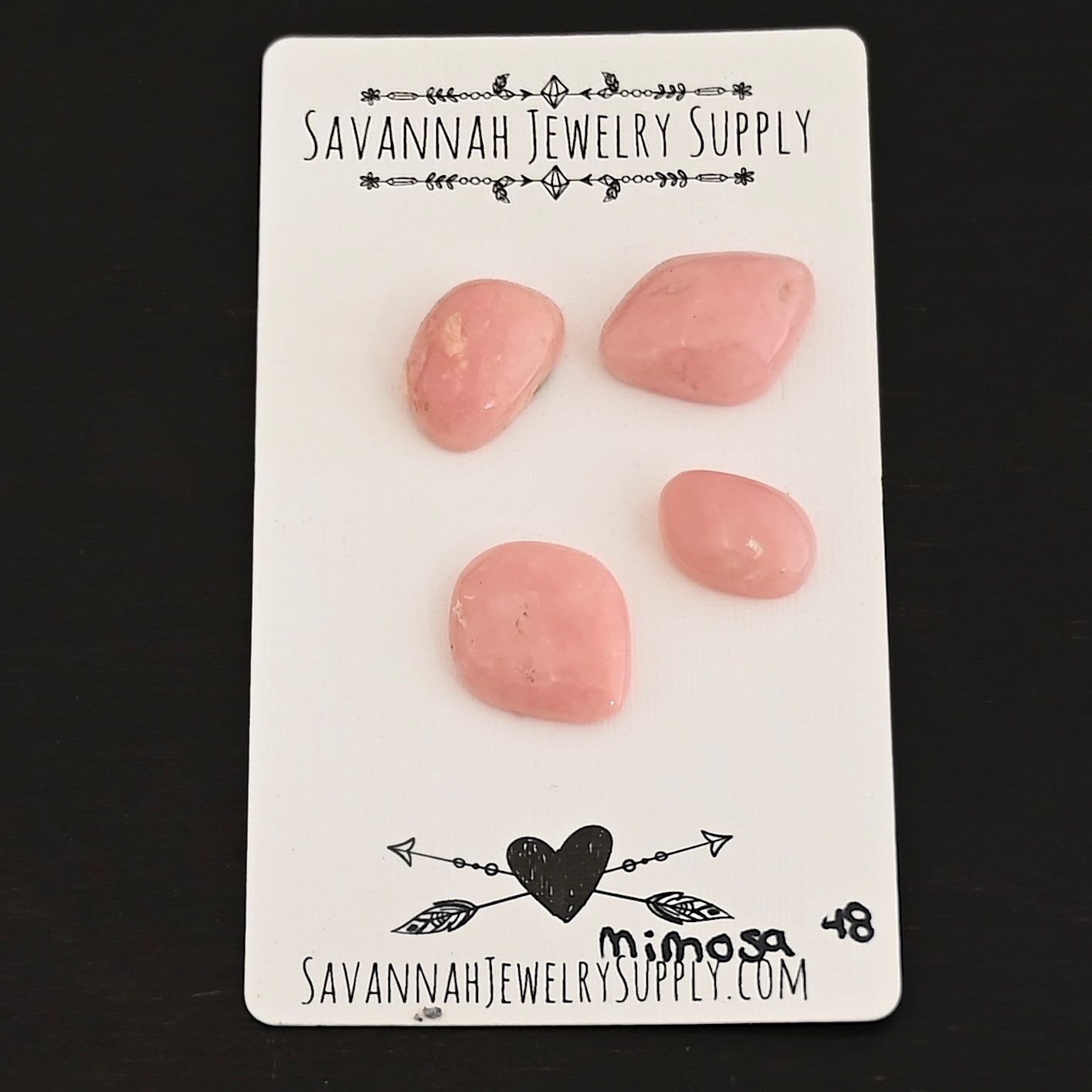 Mimosa Pink Opal cabochon parcel shown on business card