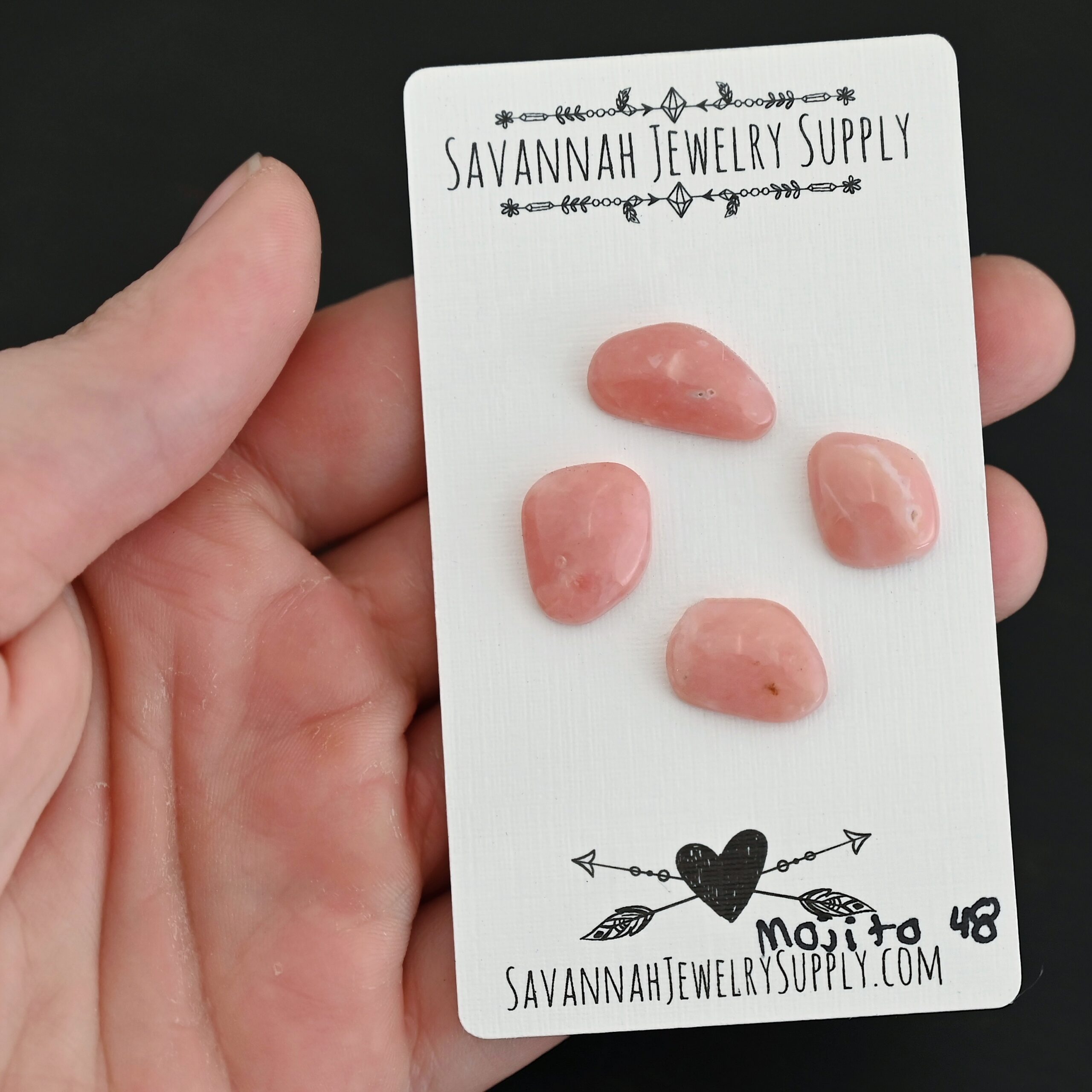 Mojito Pink Opal cabochon parcel shown in hand