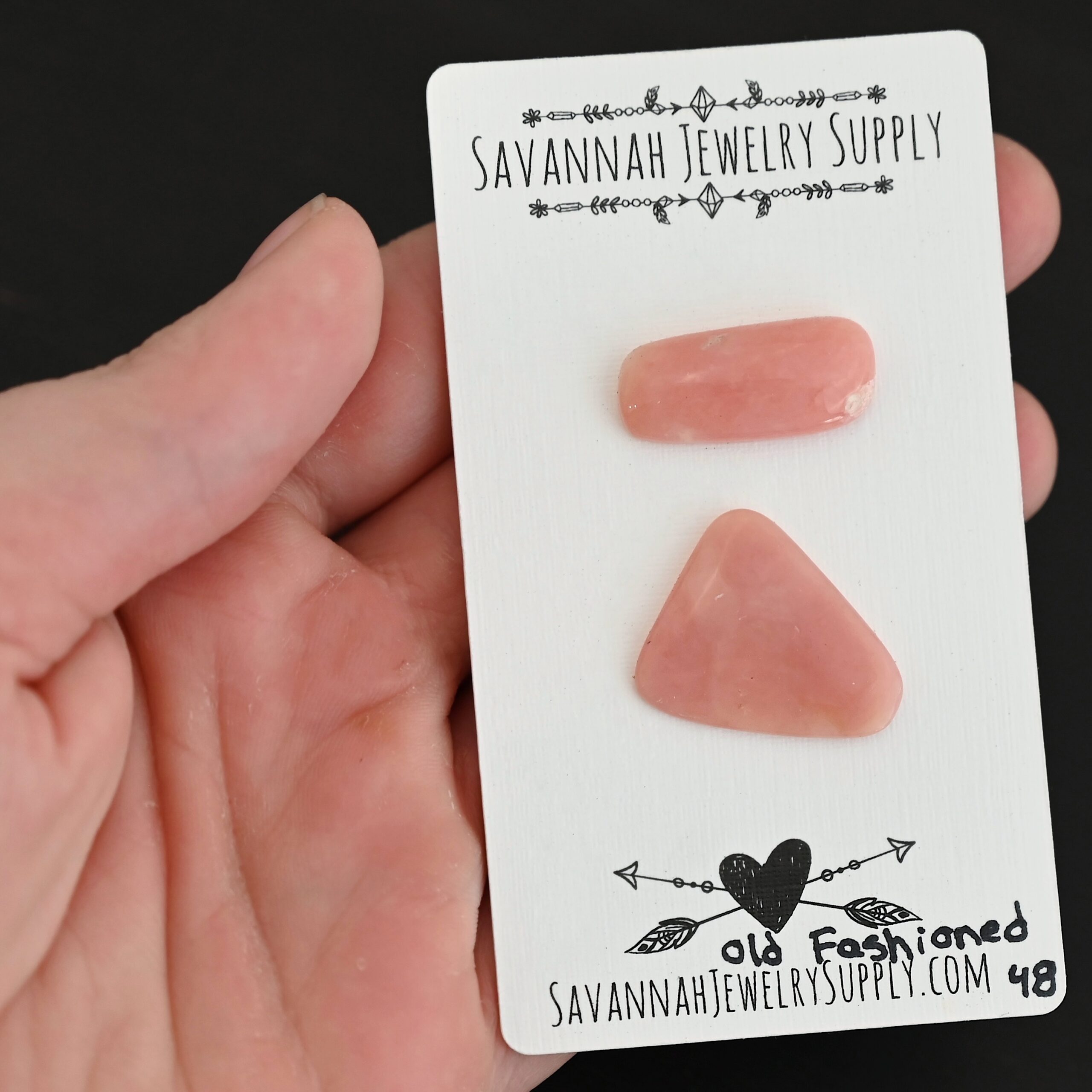 Old Fashioned Pink Opal cabochon parcel shown in hand
