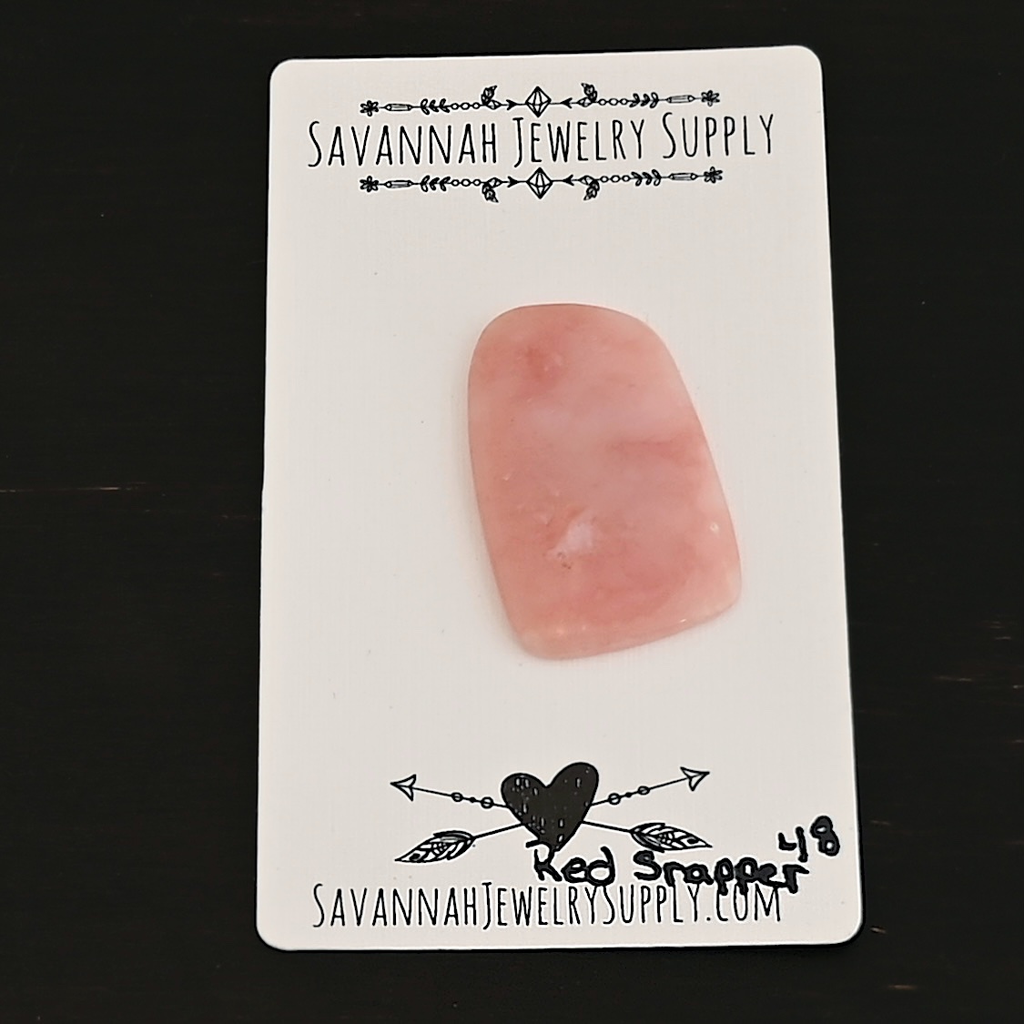 Red Snapper Pink Opal cabochon parcel shown on business card