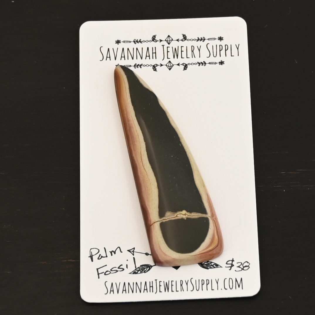 Palm Fossil Cabochon shown on business card