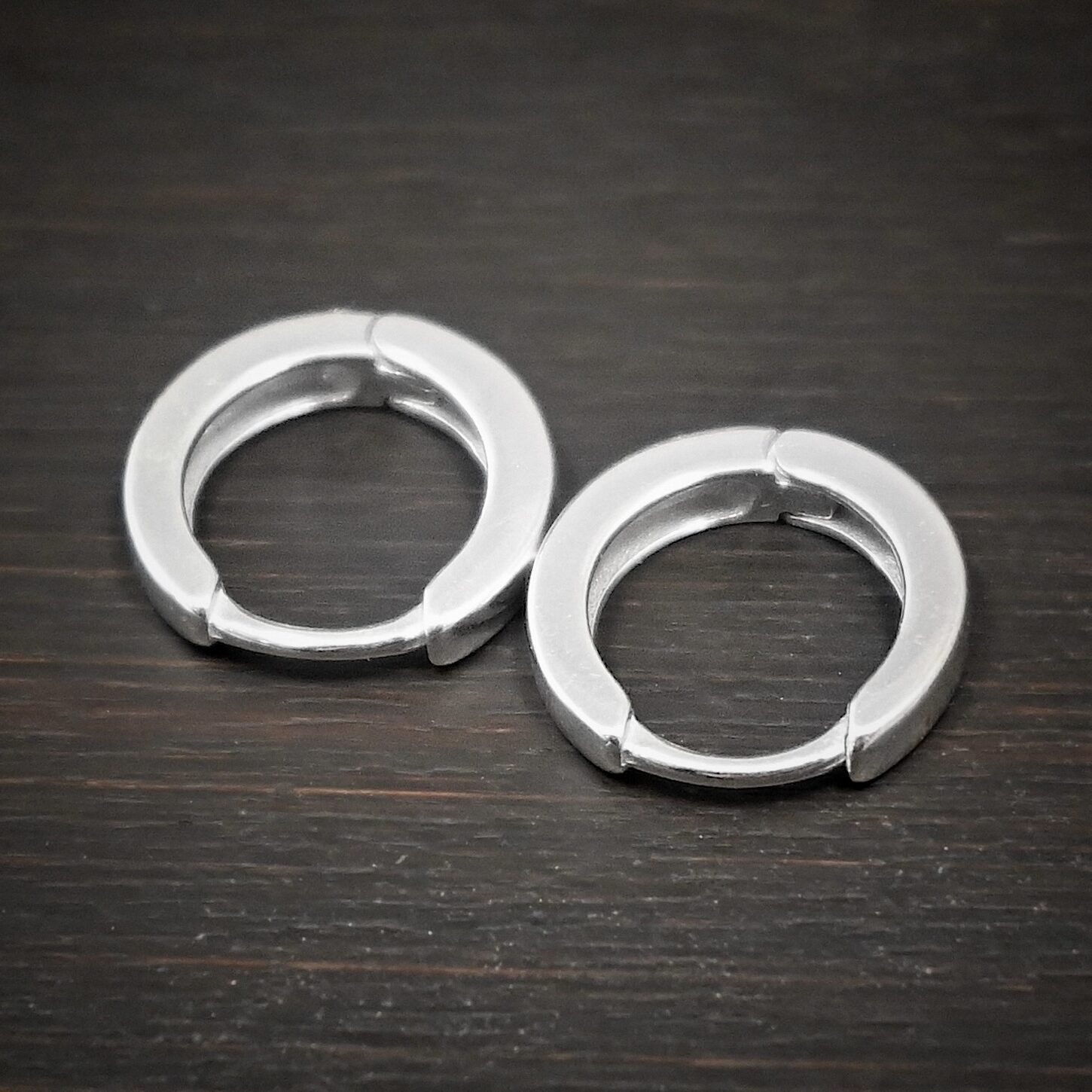 Winona Huggie Hoop Earring - shiny sterling silver Winona Huggie Hoop Earrings - shiny shown on dark background