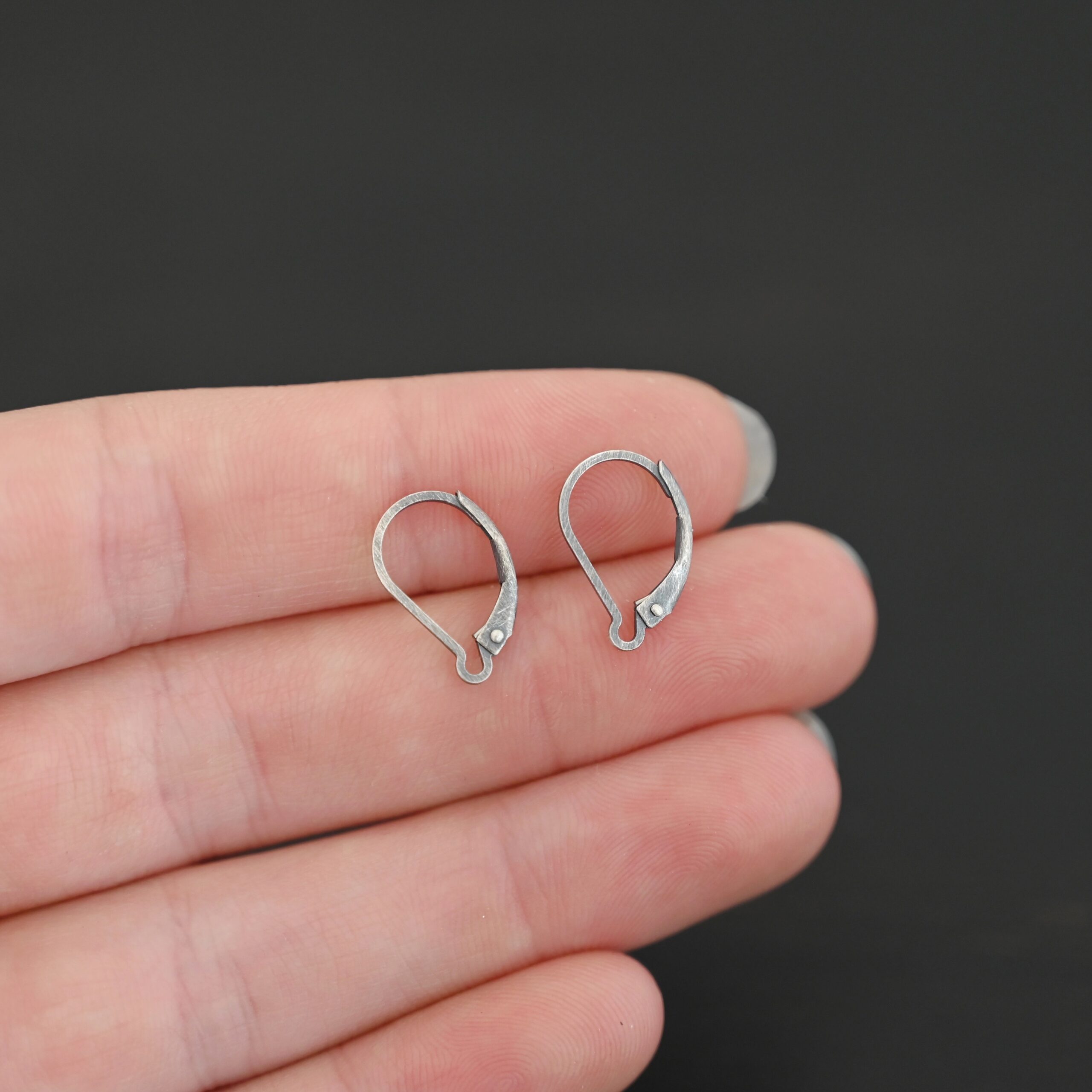 sterling silver Waverly lever back ear wires - oxidized shown in hand