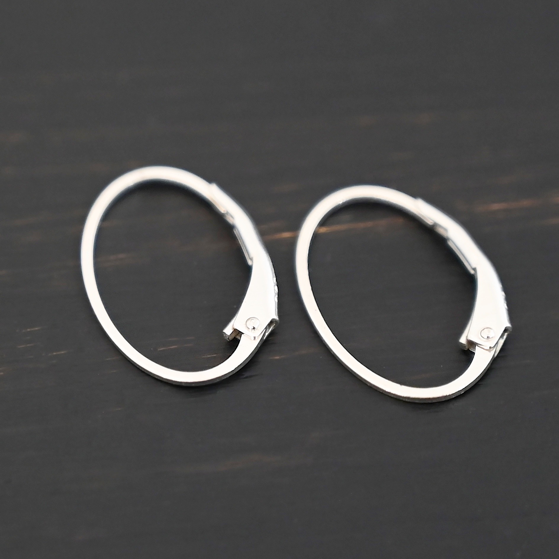 Wren leverback ear wires - shiny Sterling silver Wren lever back ear wires - shiny, shown on dark background