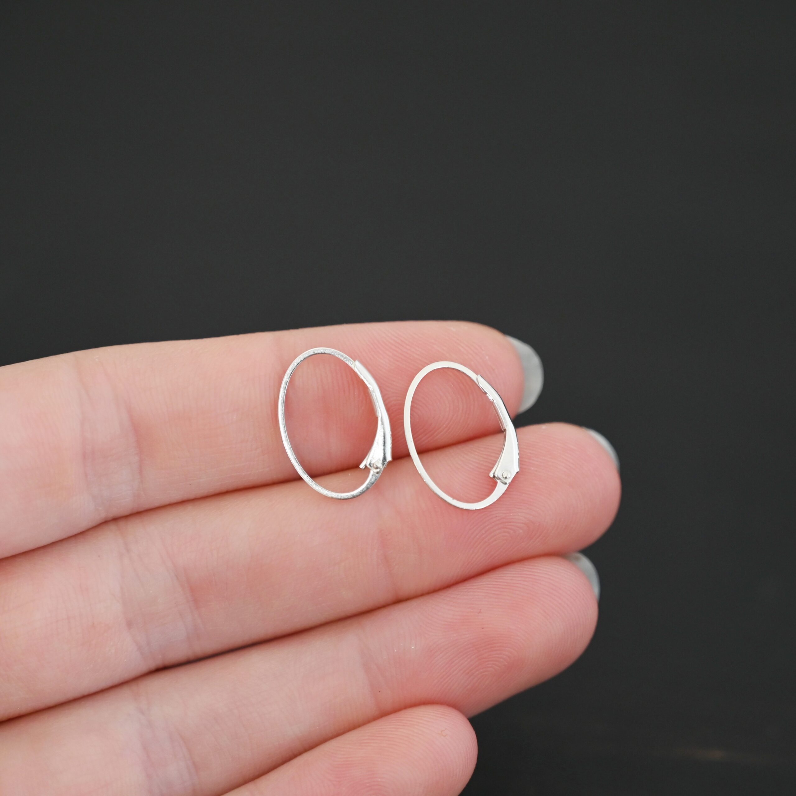 Wren leverback ear wires - shiny Sterling silver Wren lever back ear wires - shiny, shown in hand