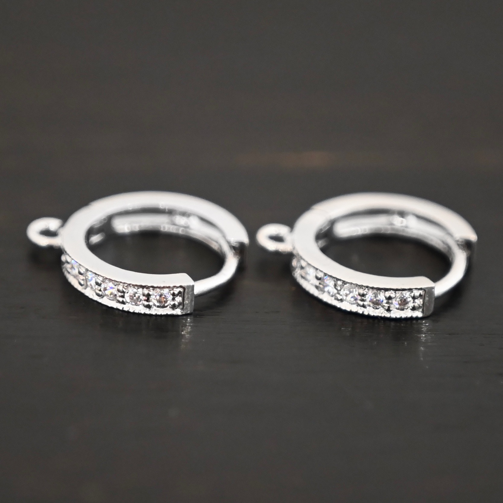 Rhodium Plated Sterling Silver Wisdom CZ Huggie Hoops shown on dark background