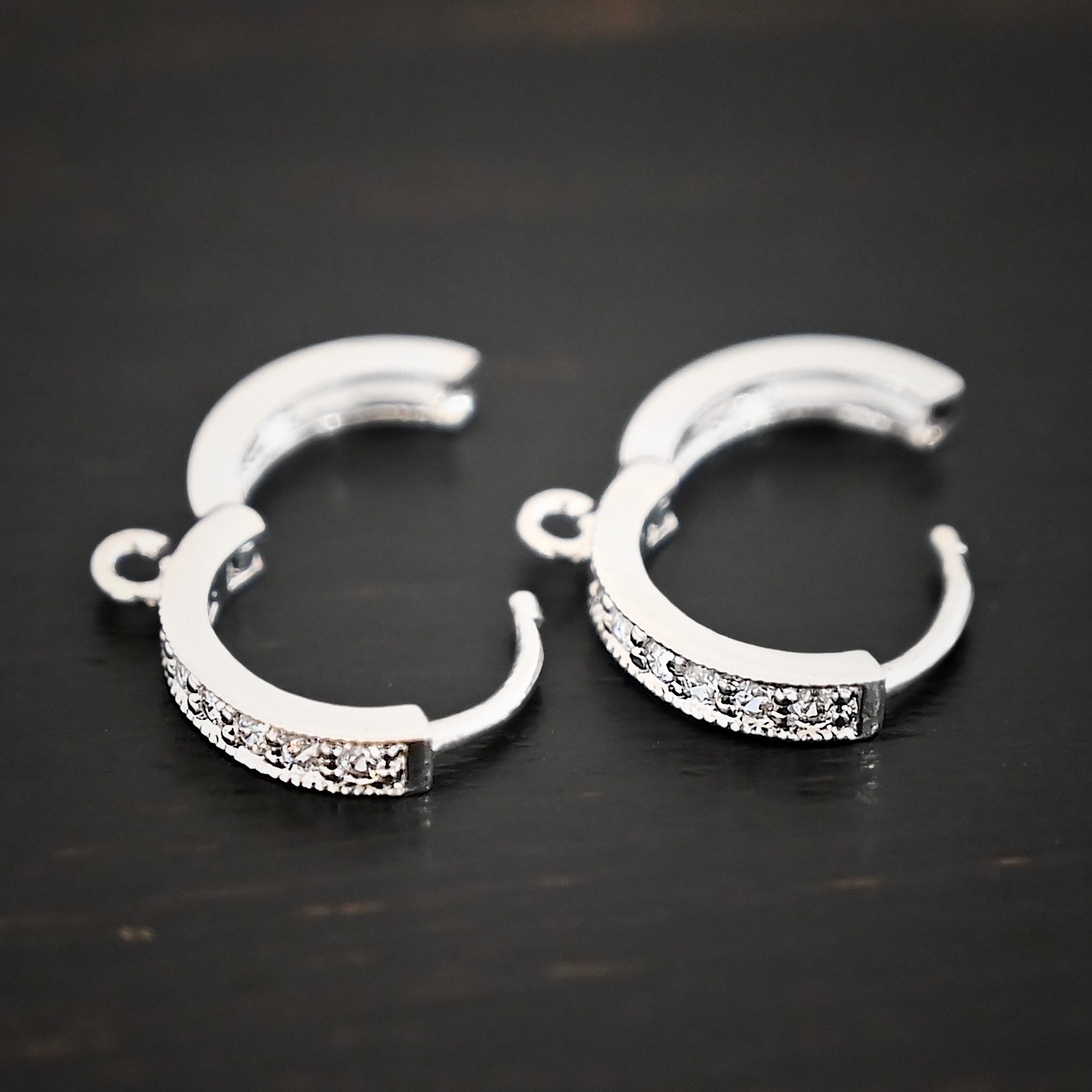 Rhodium Plated Sterling Silver Wisdom CZ Huggie Hoops shown on dark background