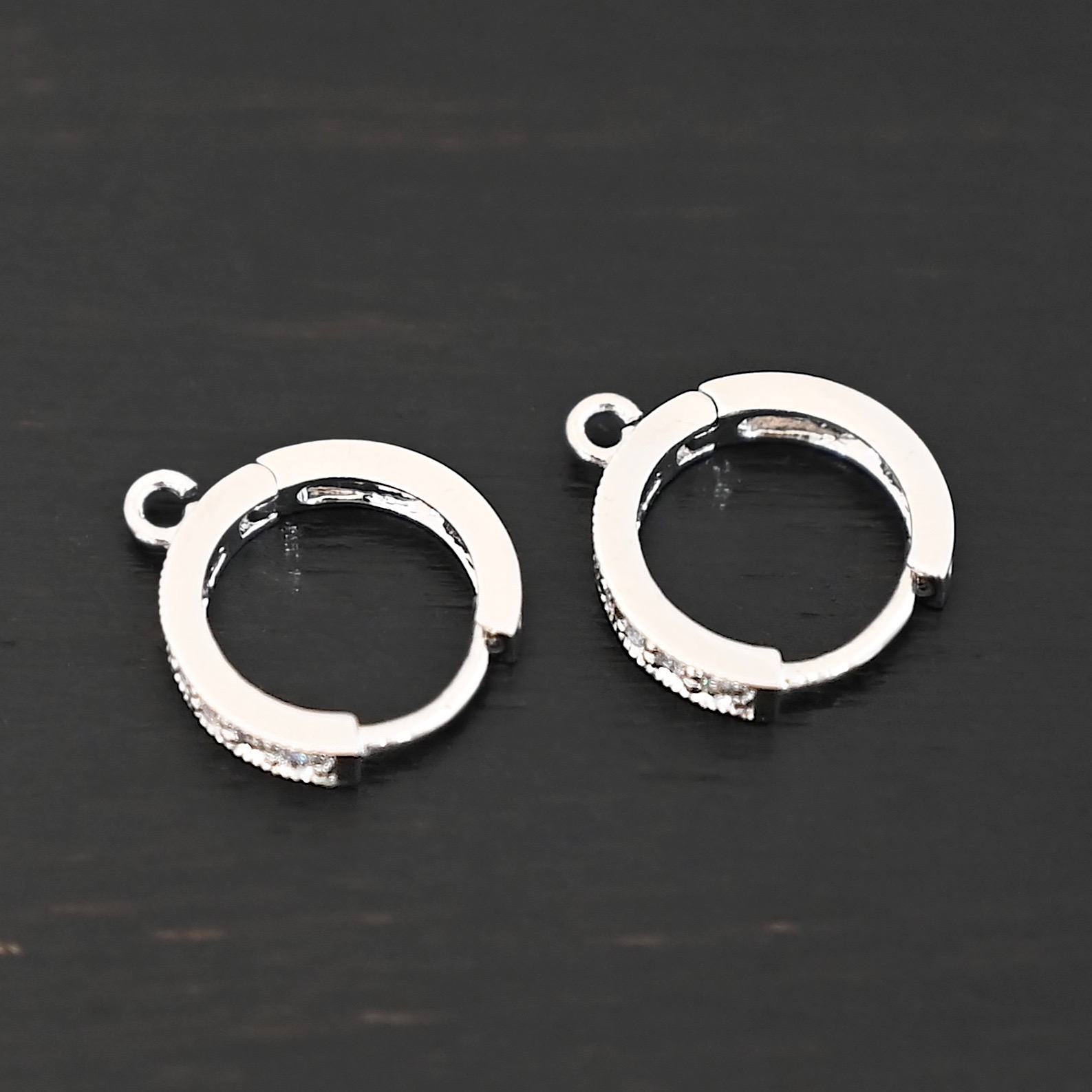 Rhodium Plated Sterling Silver Wisdom CZ Huggie Hoops shown on dark background