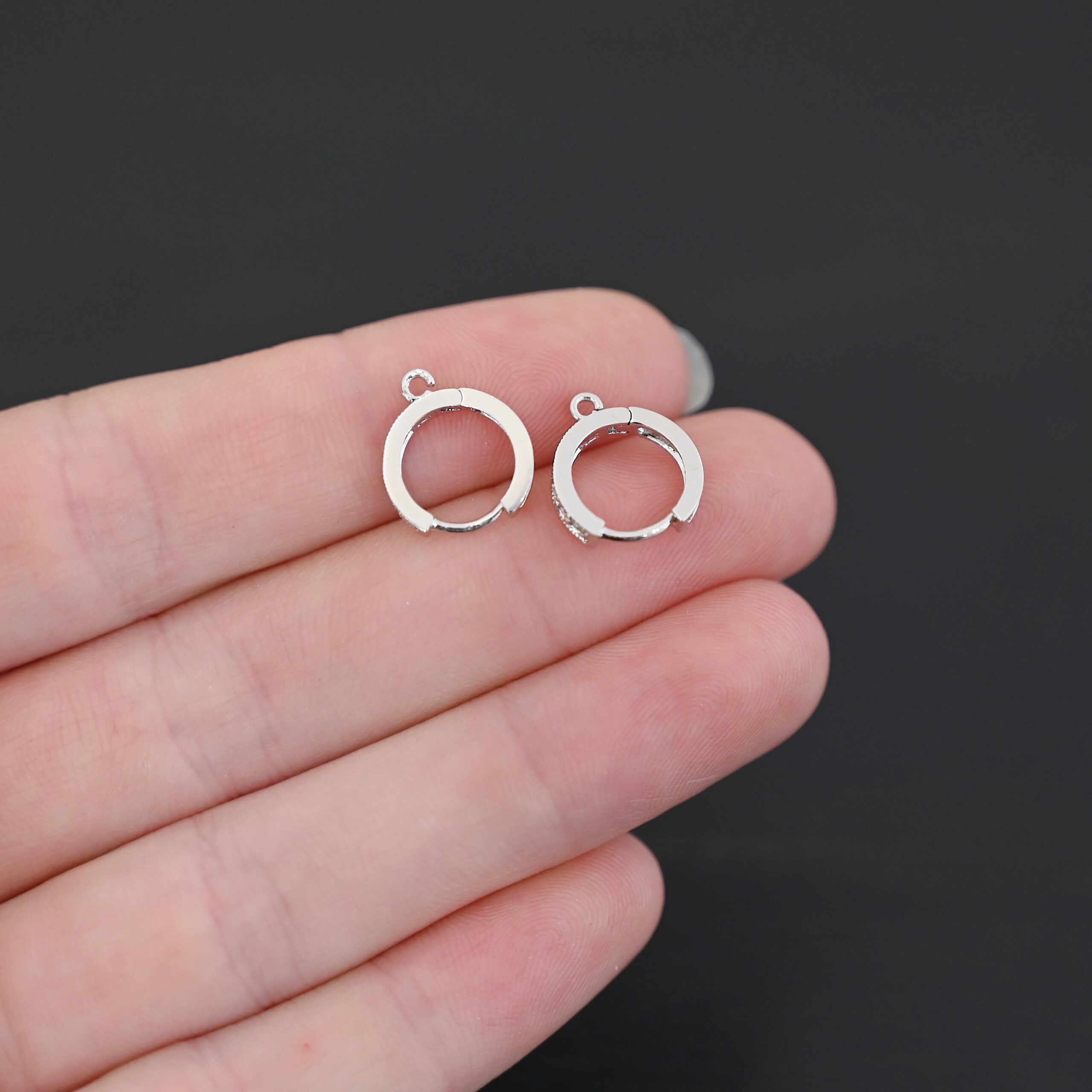 Rhodium Plated Sterling Silver Wisdom CZ Huggie Hoops shown in hand