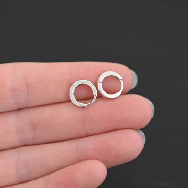 sterling silver Winona Huggie Hoop Earrings - shiny shown in hand