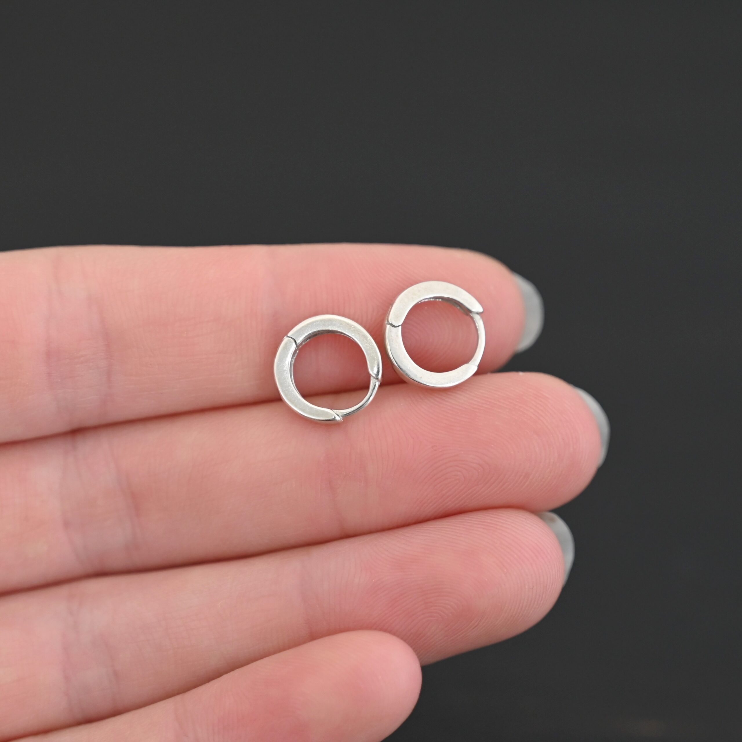 Winona Huggie Hoop Earrings - shiny sterling silver Winona Huggie Hoop Earrings - shiny shown in hand