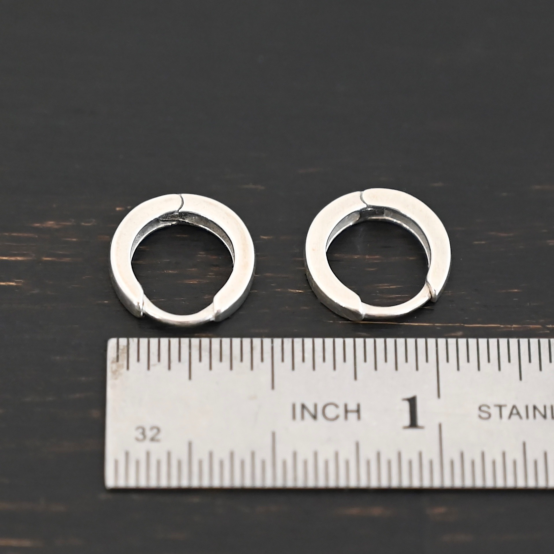 Winona Huggie Hoop Earrings - shiny sterling silver Winona Huggie Hoop Earrings - shiny shown by ruler