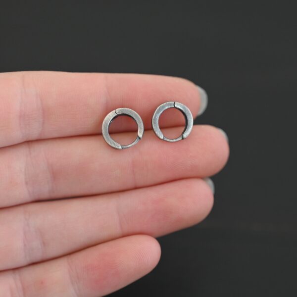 sterling silver Winona Huggie Hoop Earrings - oxidized shown in hand