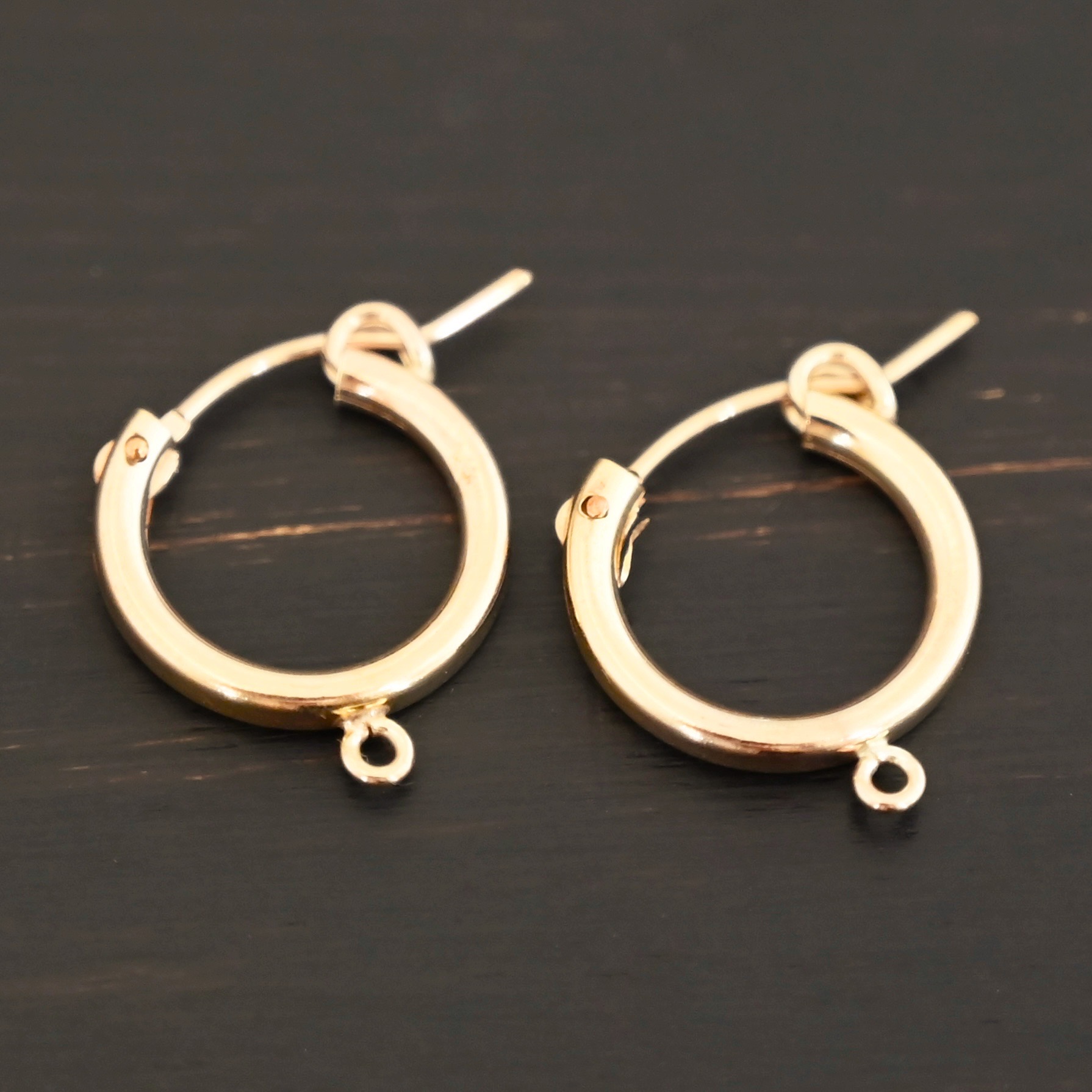 West 14k gold filled hoops shown on dark background